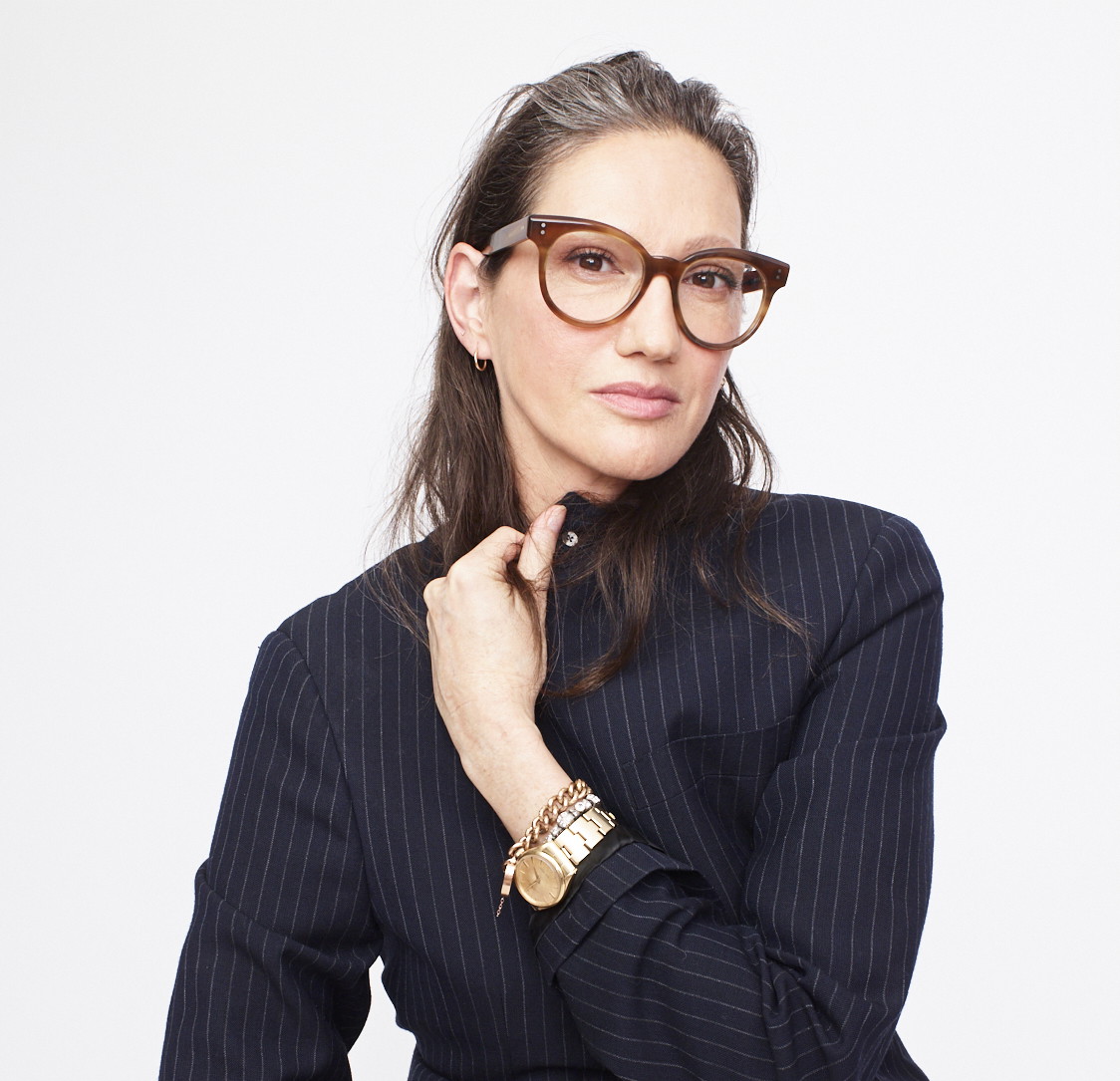 a woman in a suit and glasses posing for a picture