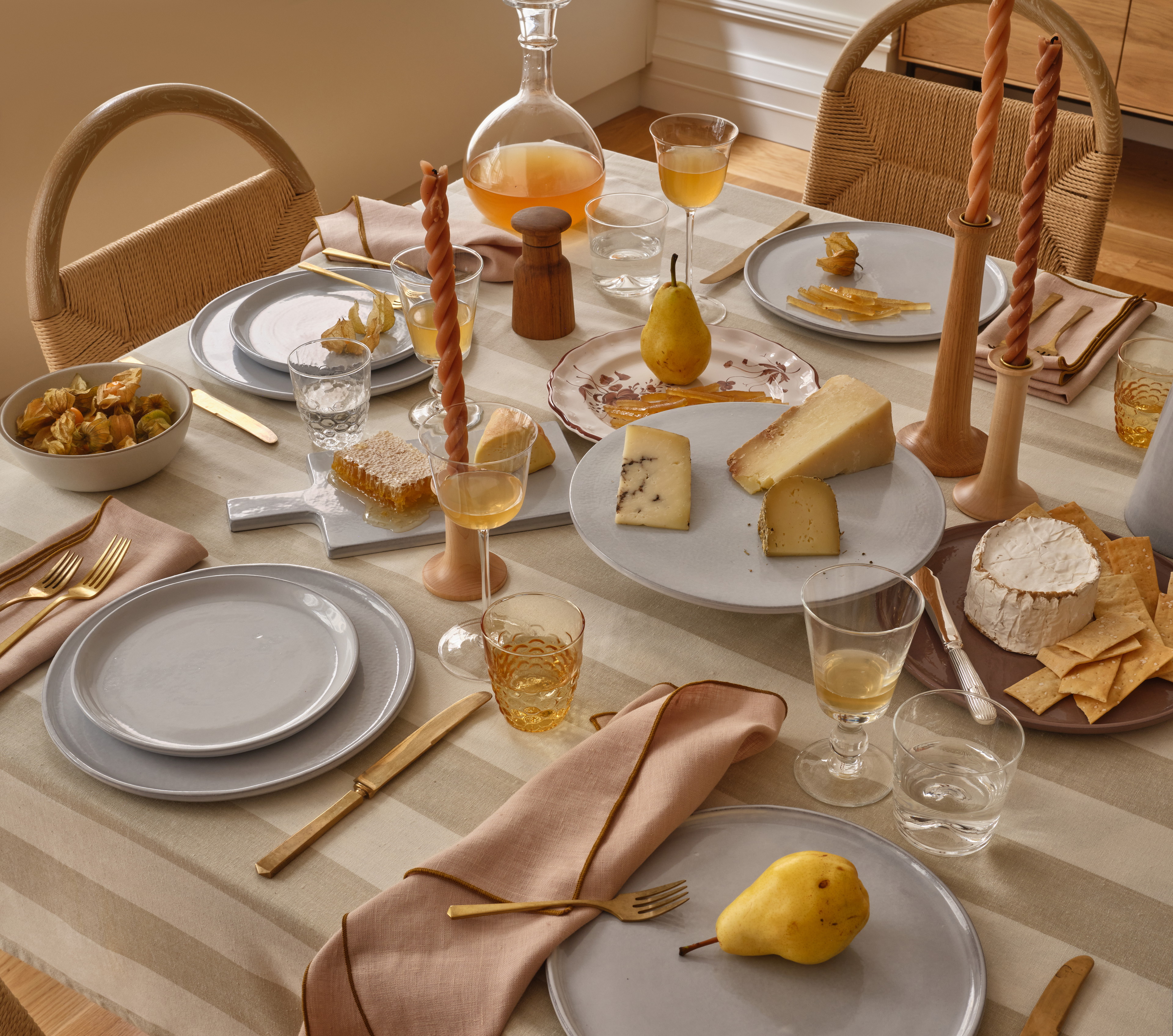 a table set with plates, silverware and a pear