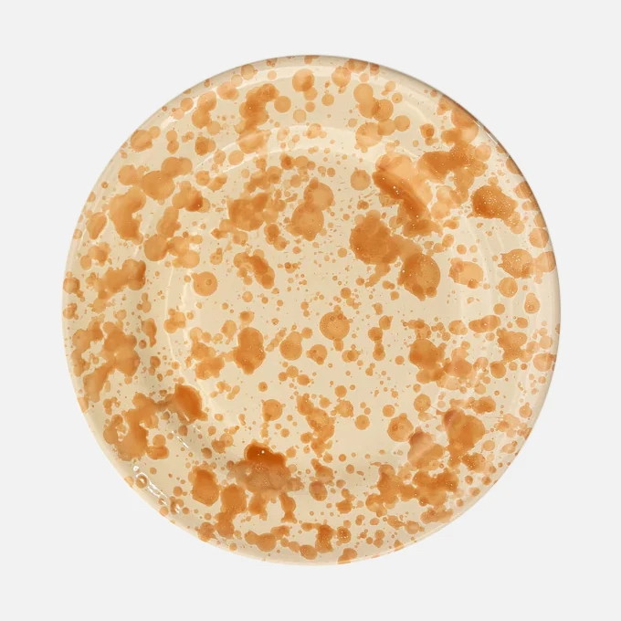a white plate with brown spots on it