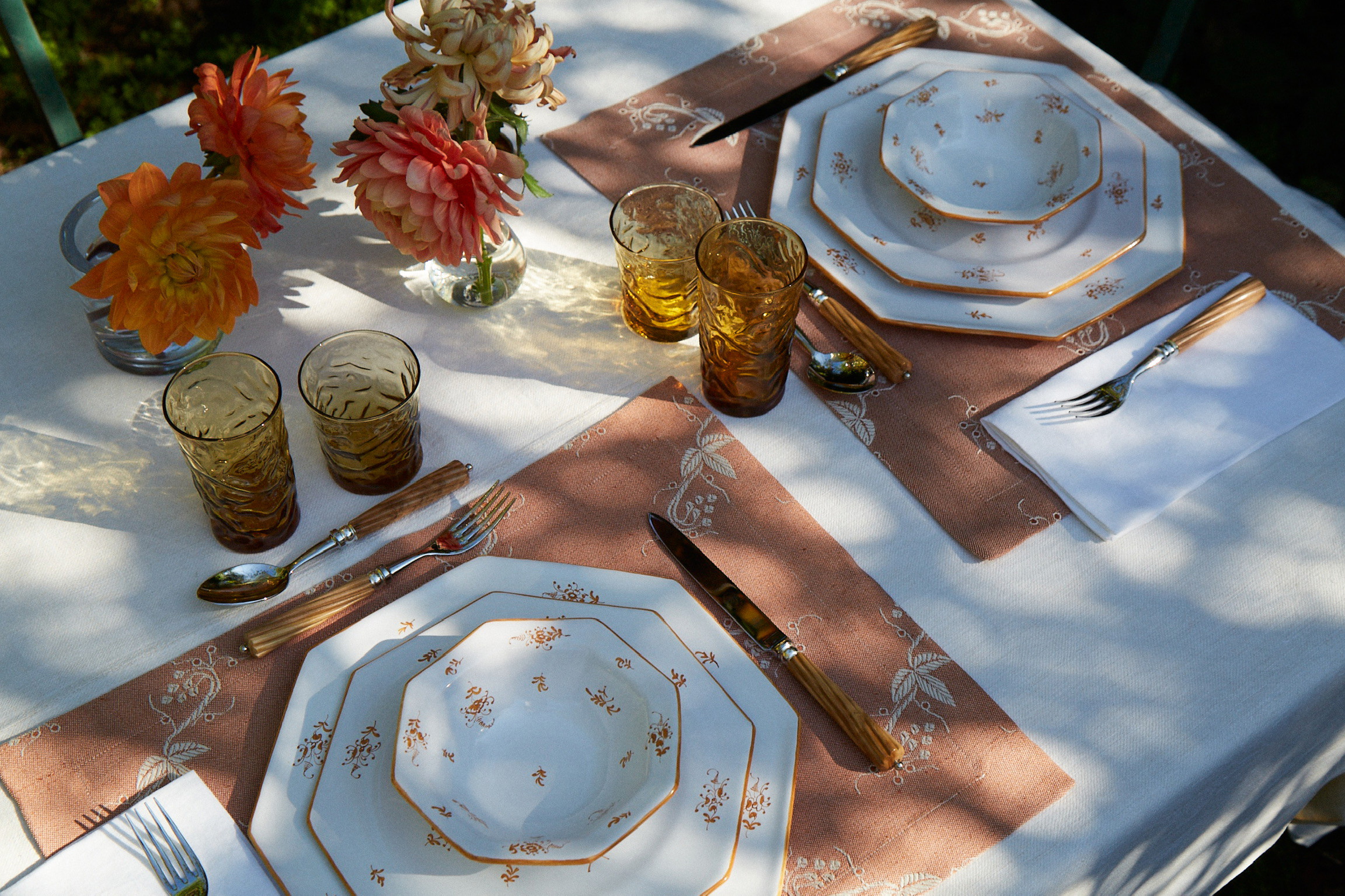 a table set for a formal dinner outdoors