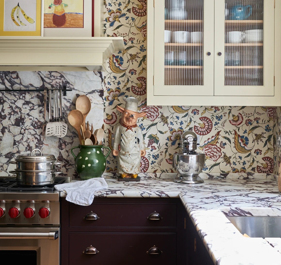a kitchen with a sink, stove, cabinets and pictures on the wall
