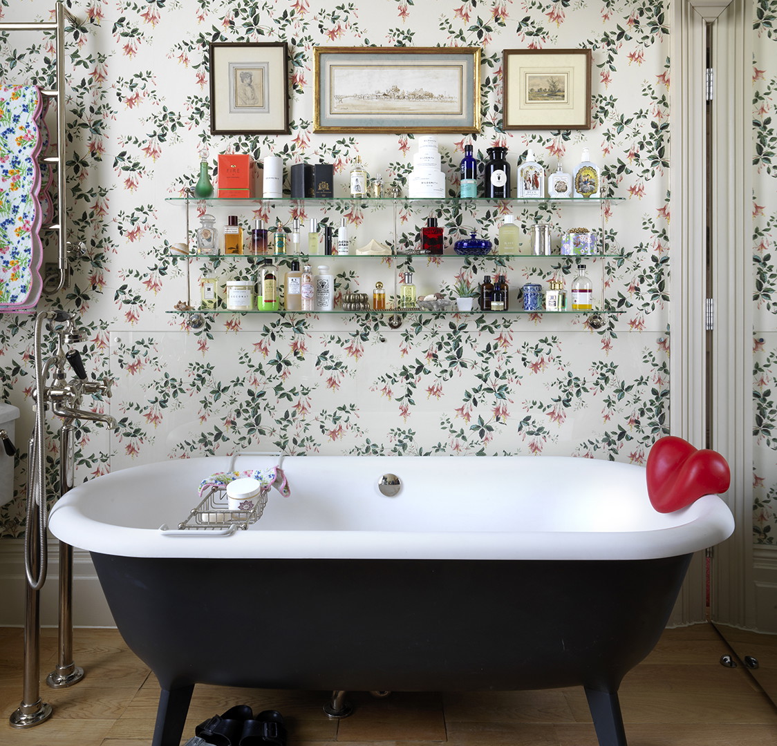 a bathroom with a claw foot tub and a wall with pictures on it