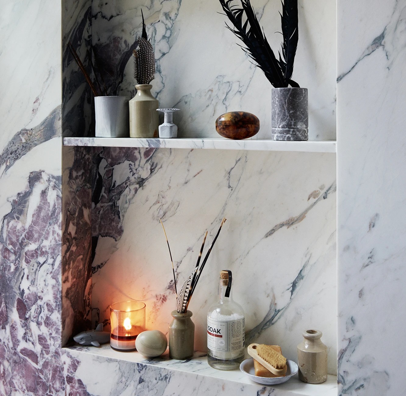 a marble shelf with candles and vases on it