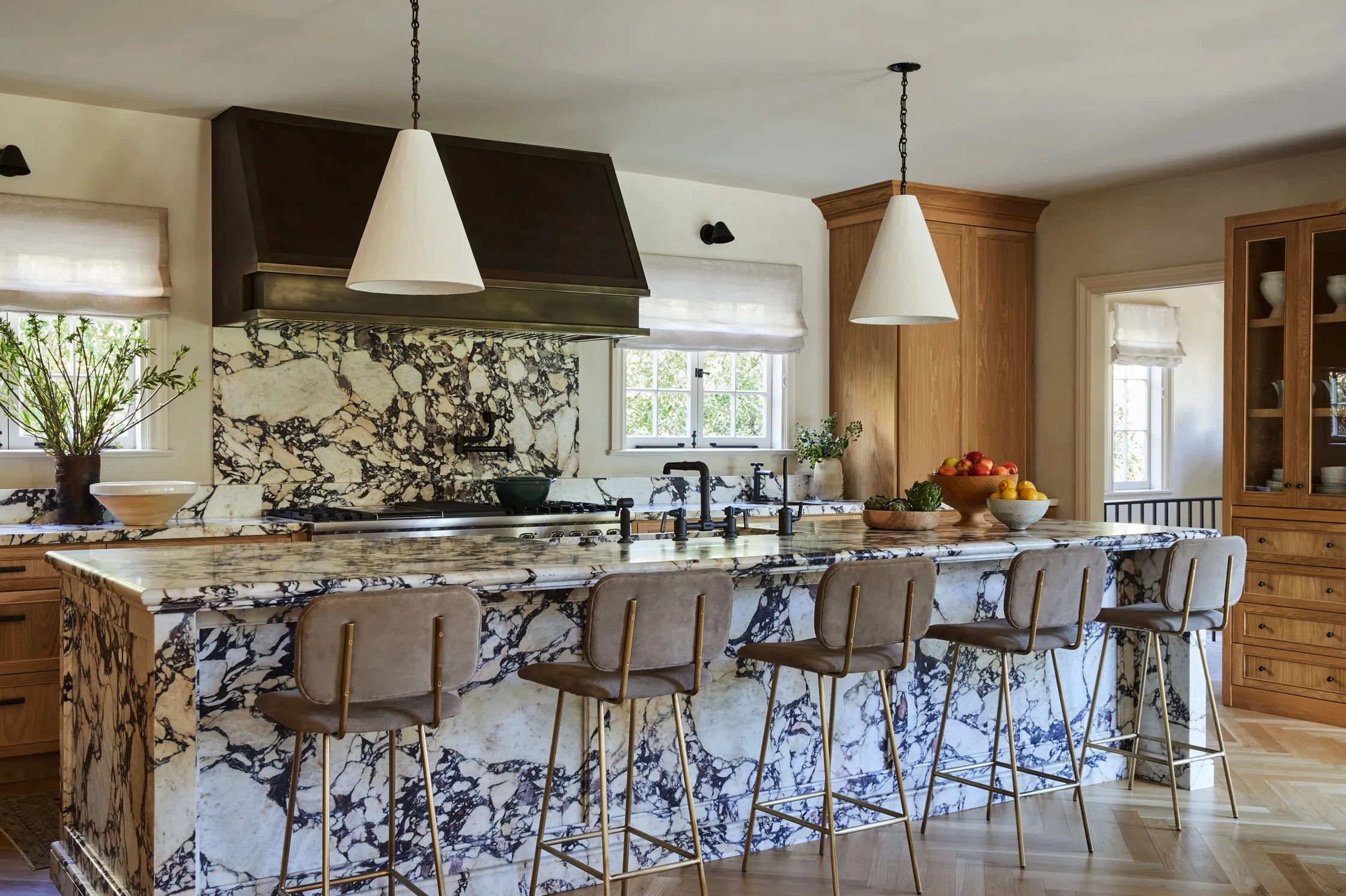 a kitchen with marble counter tops and bar stools