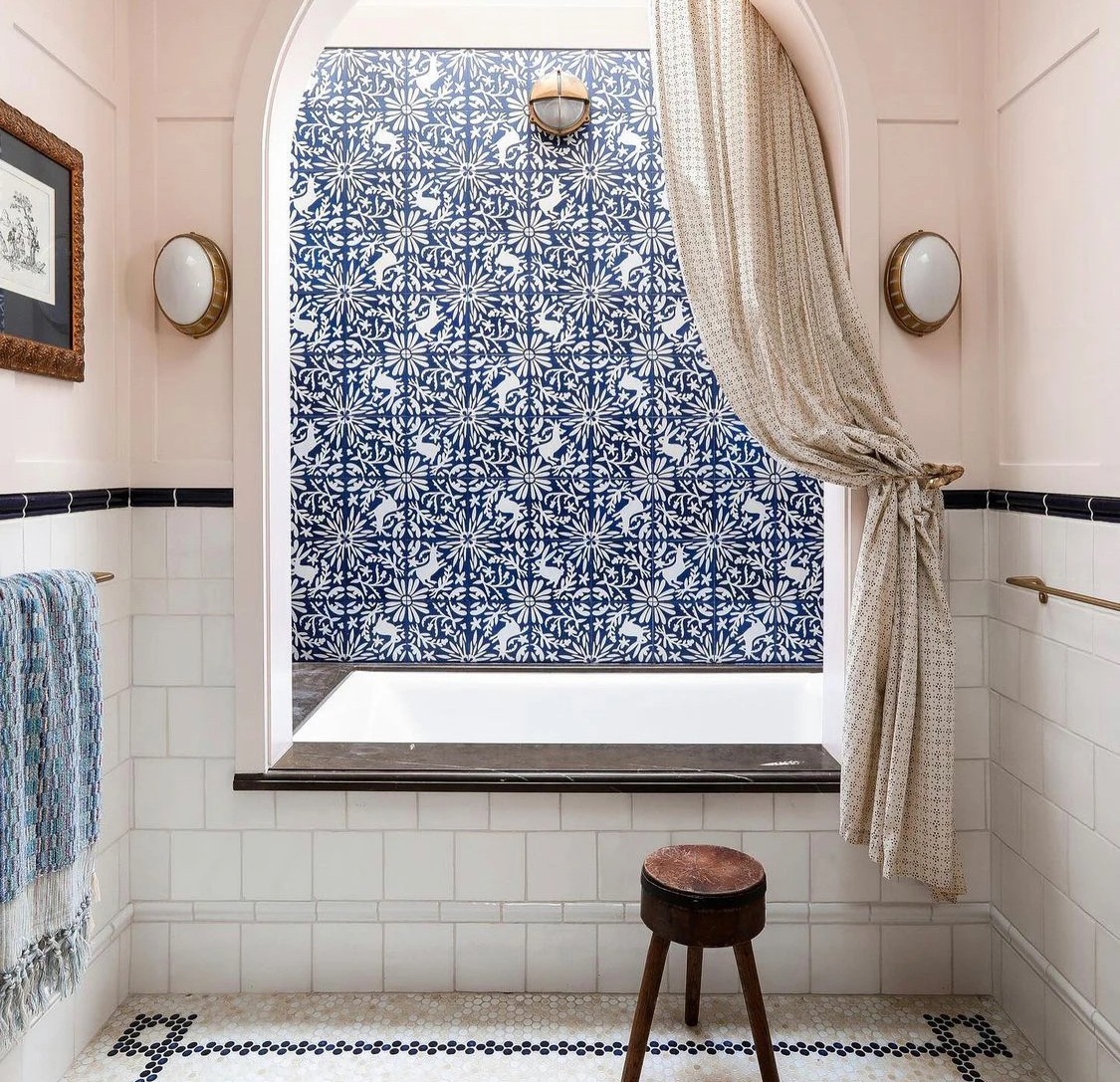 a blue and white tiled bathroom with a window