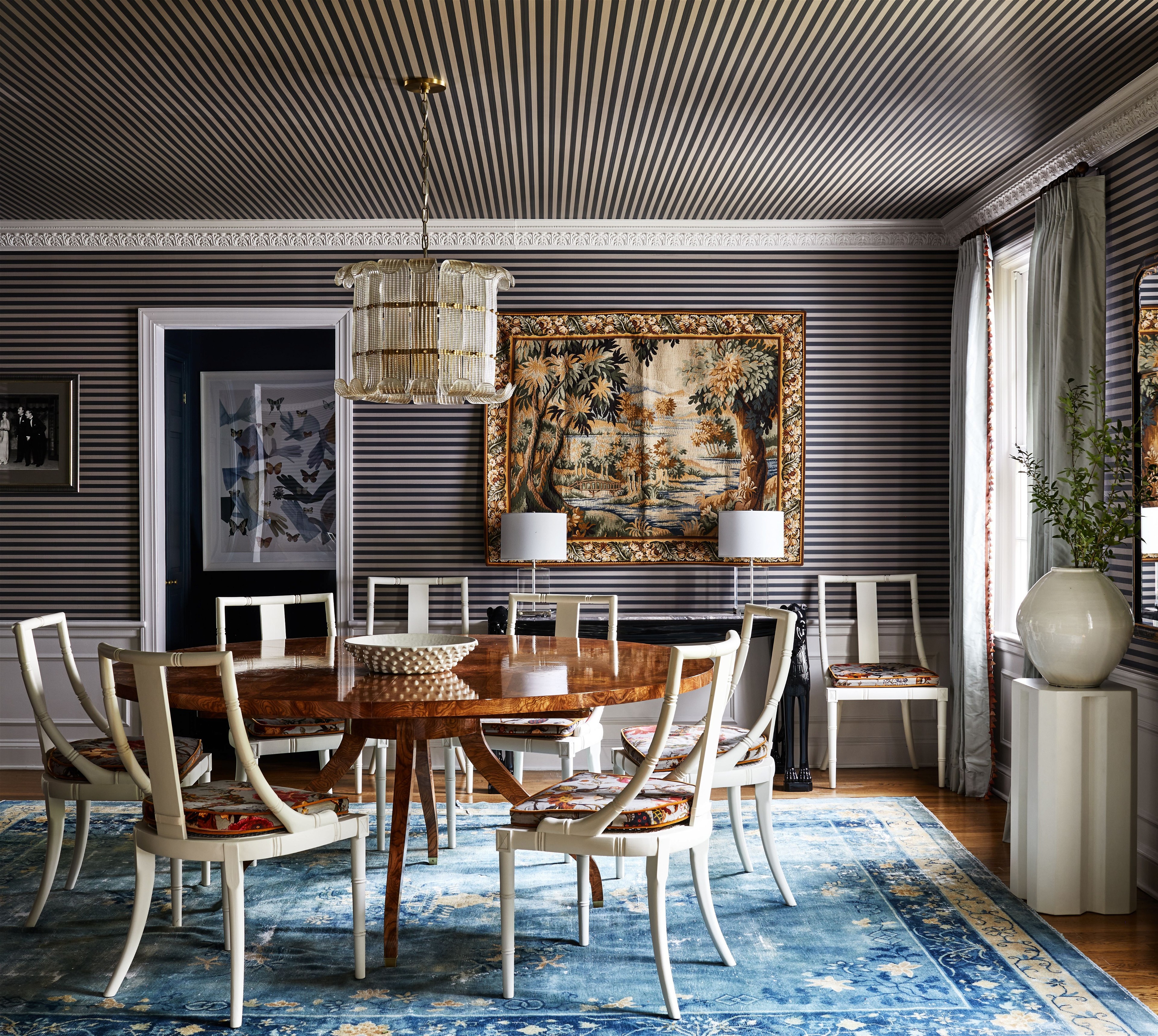 a dining room with a rug and a painting on the wall