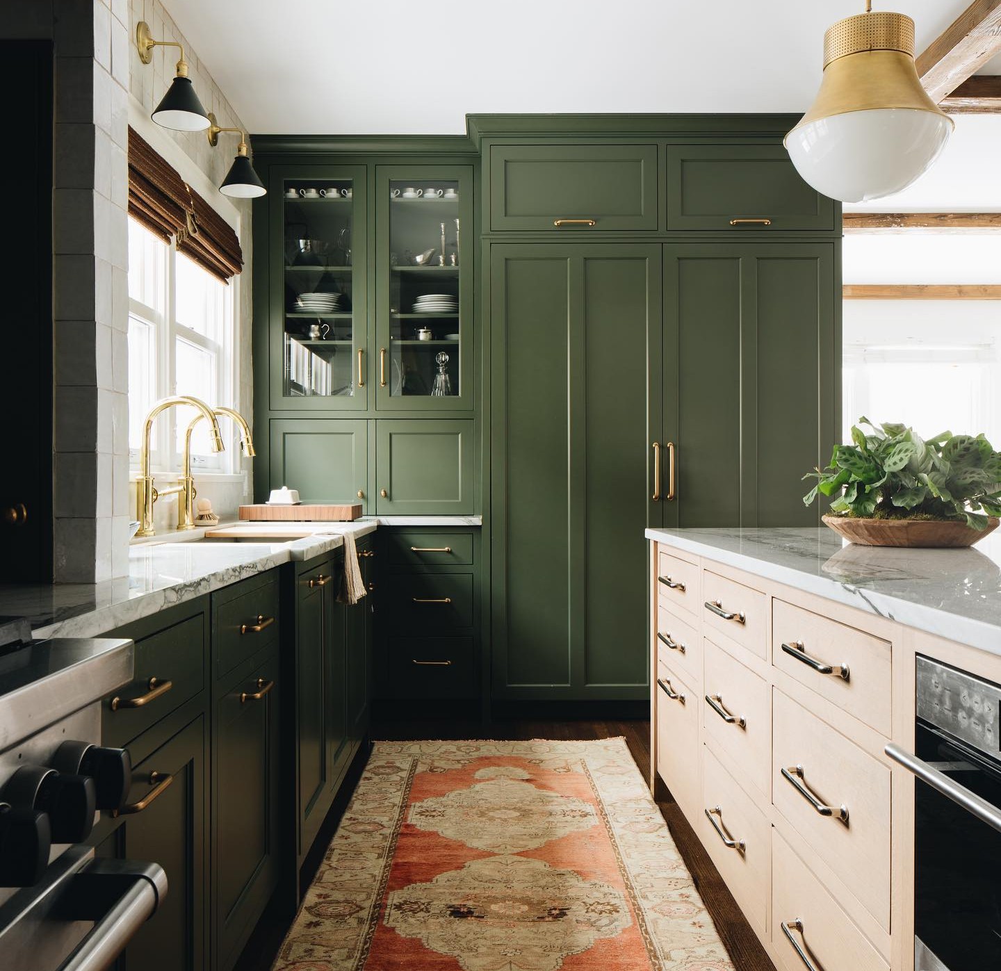 a kitchen with green cabinets and a rug on the floor