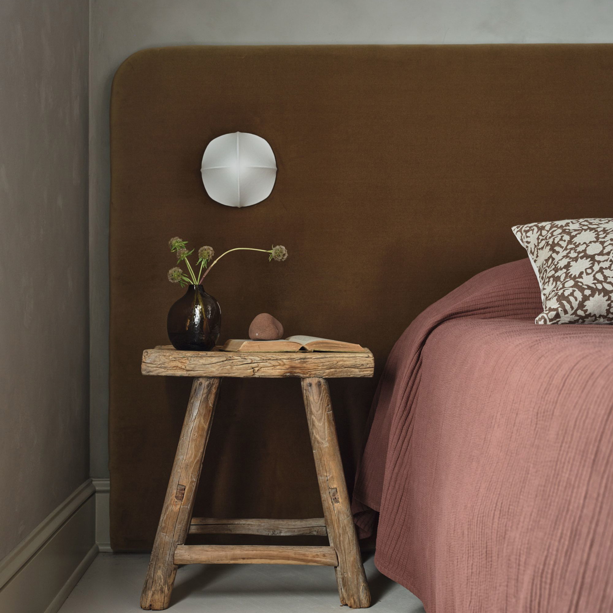 a bed with a brown headboard and a wooden table