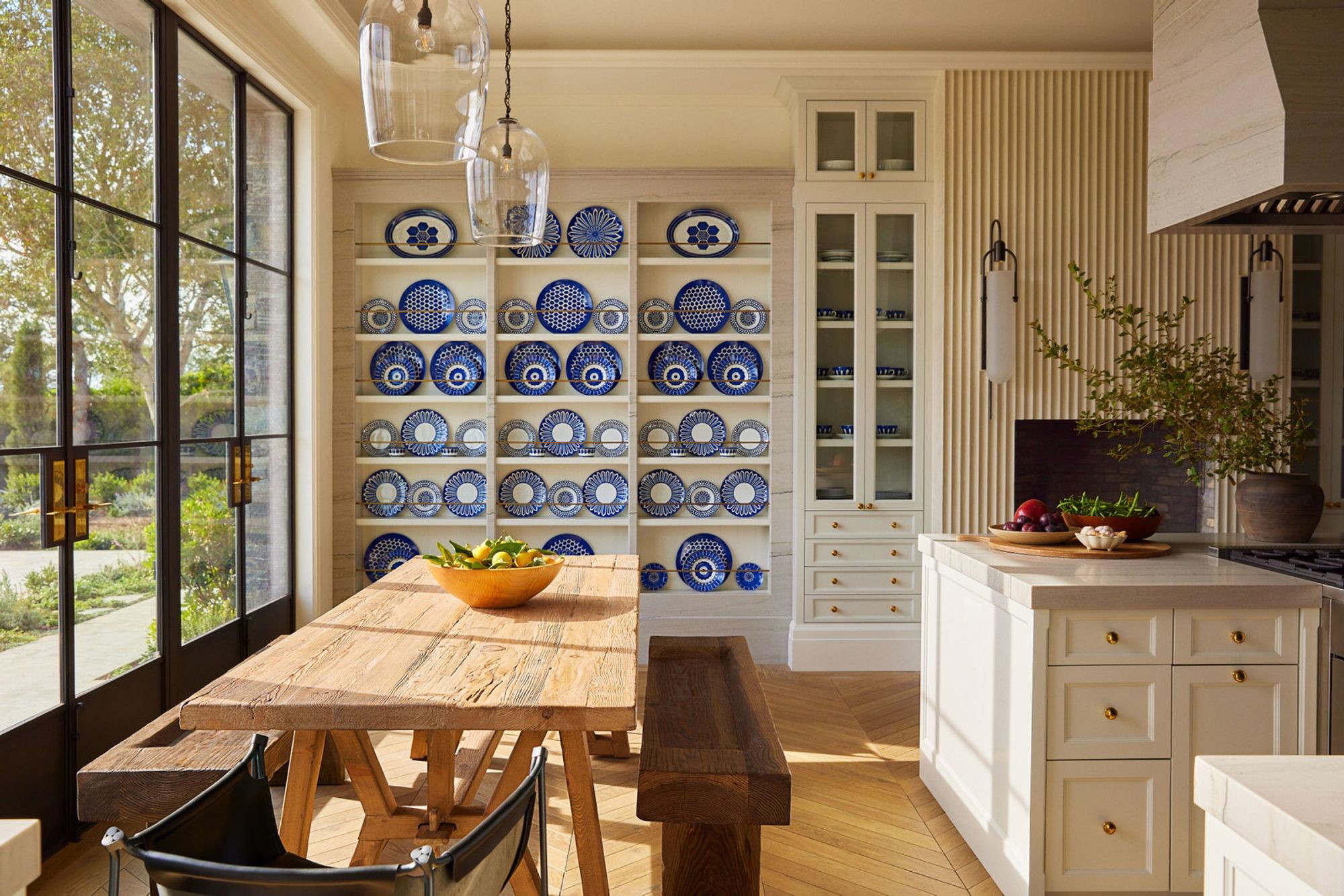 a kitchen with a wooden table surrounded by blue and white plates