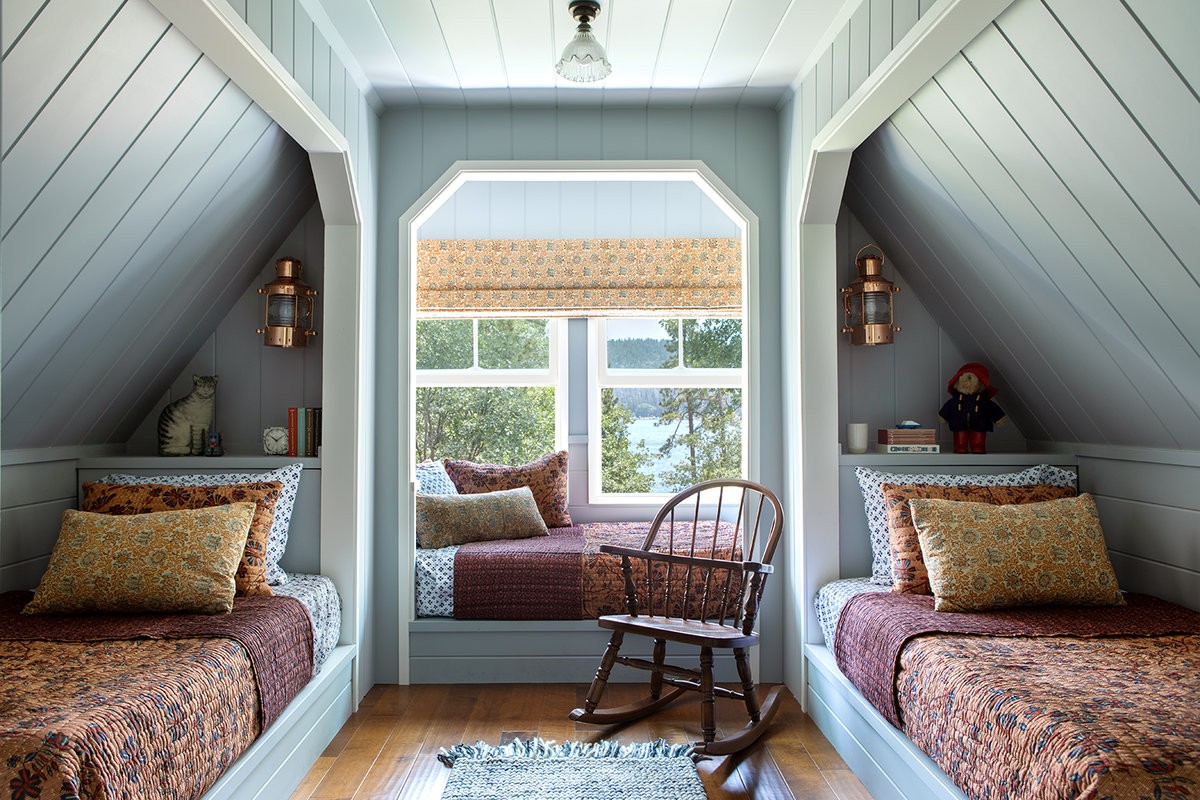 a bedroom with two beds and a rocking chair