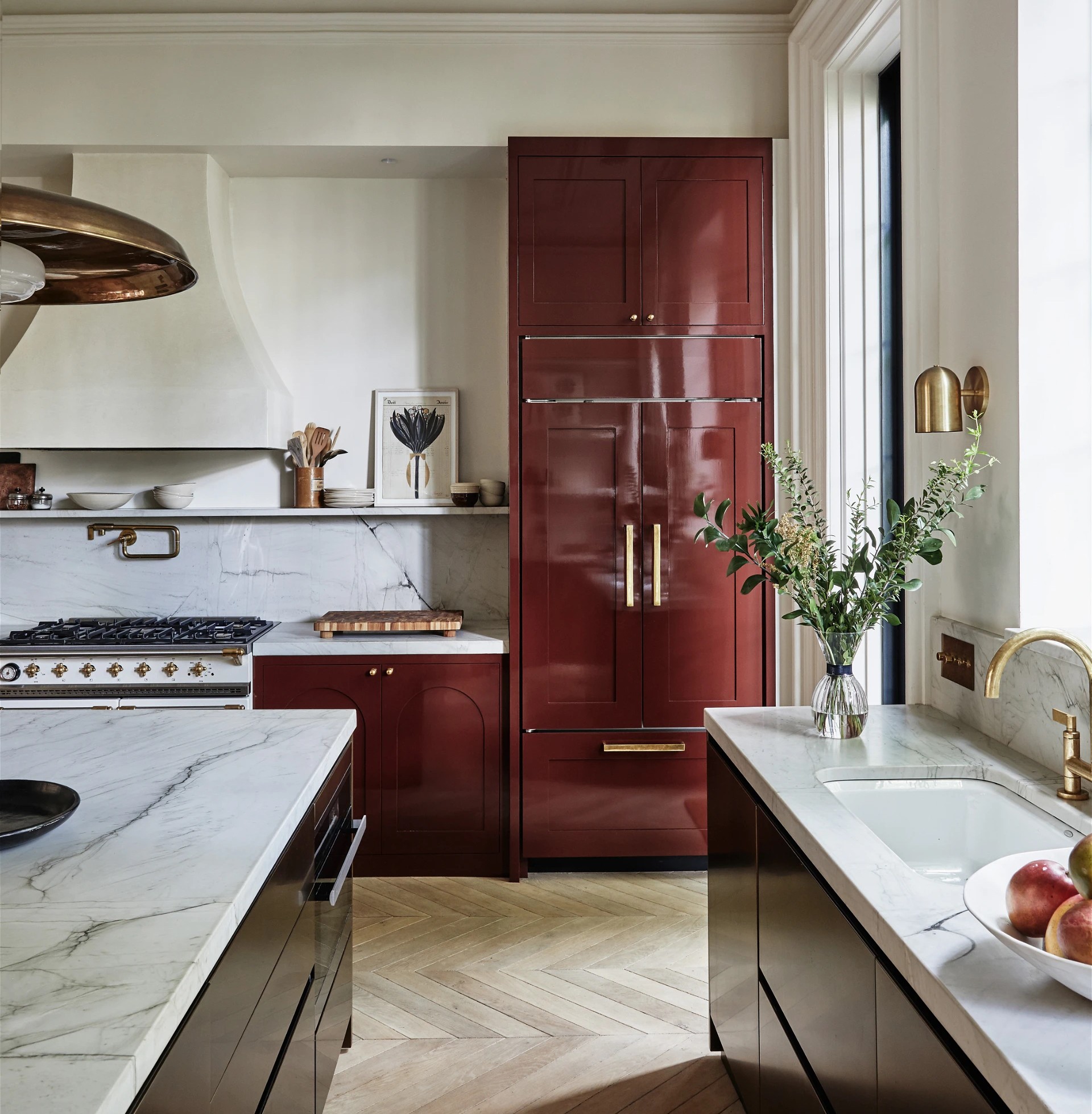 a kitchen with a marble counter top and red cabinets
