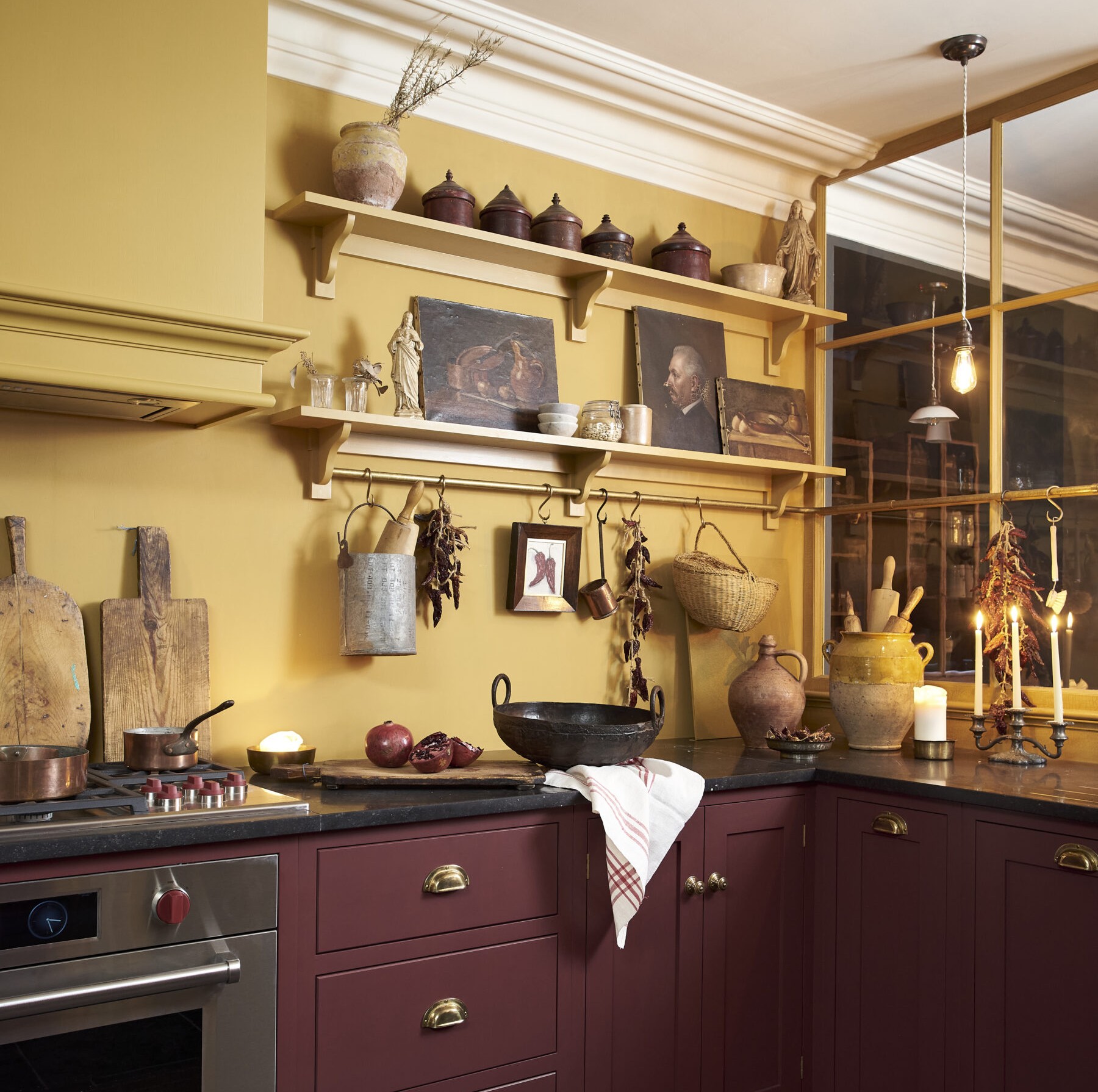 a kitchen with yellow walls and red cabinets