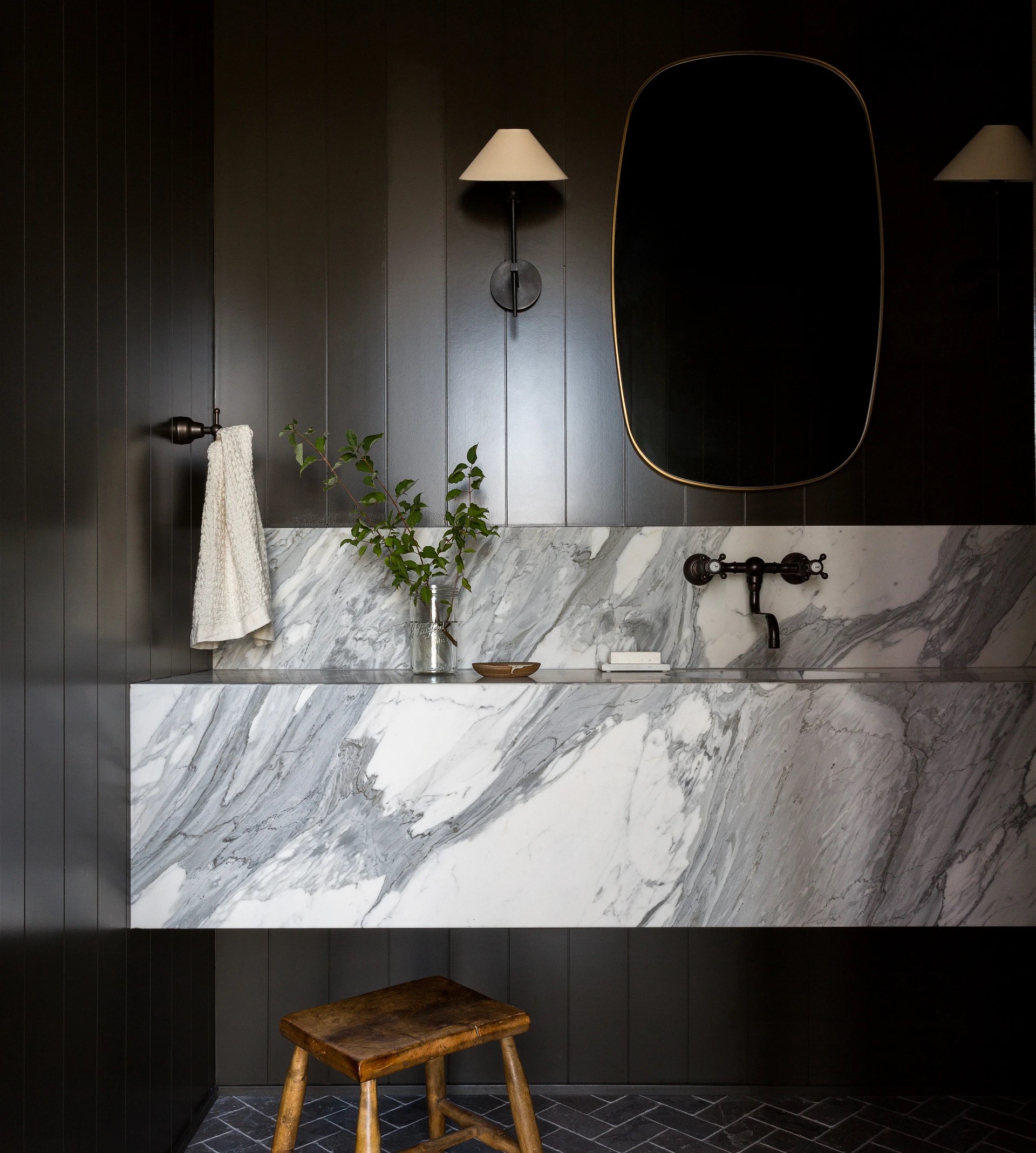 a bathroom with a marble counter top and stool