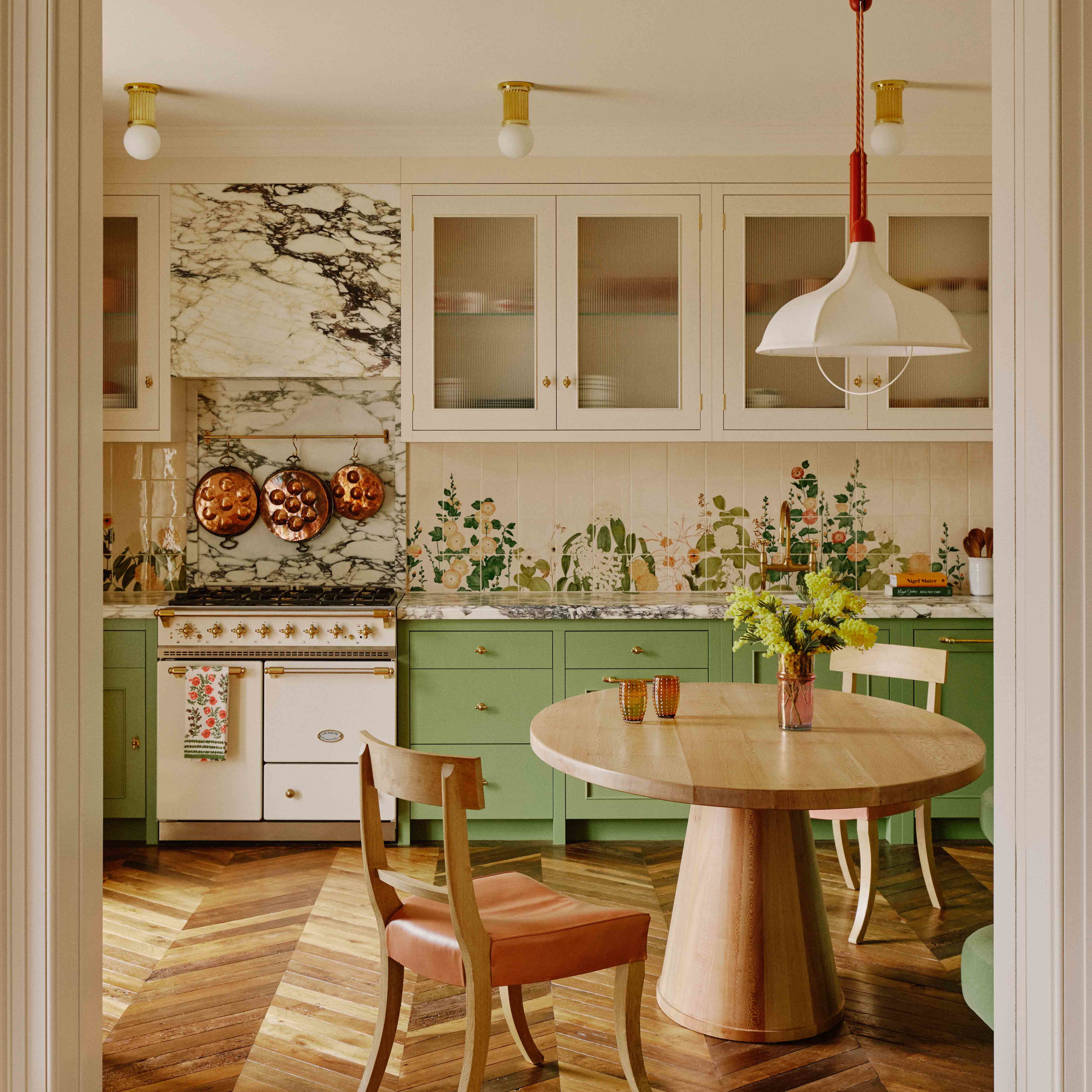 a kitchen with green cabinets and a wooden table