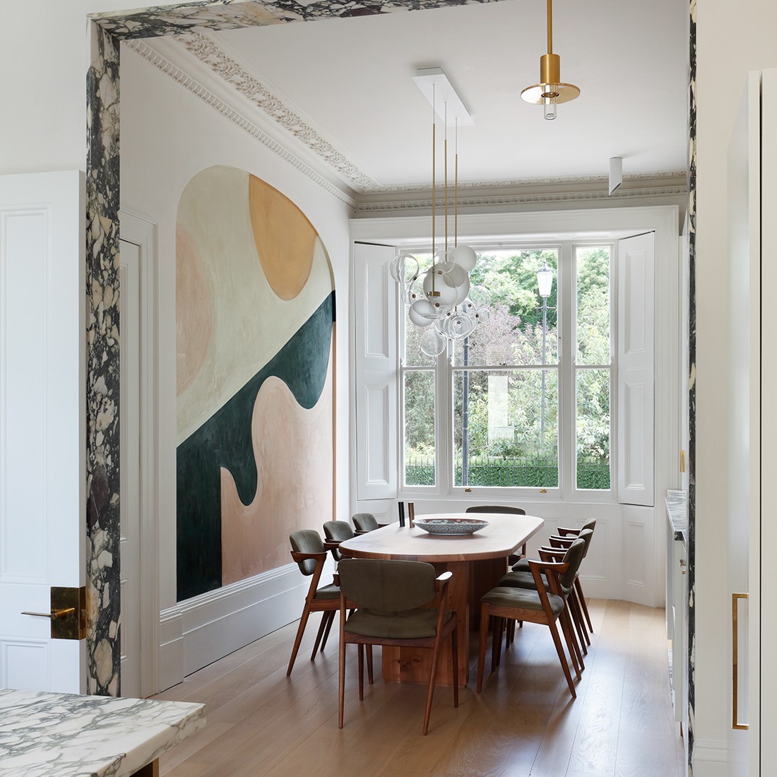 a dining room with a large painting on the wall