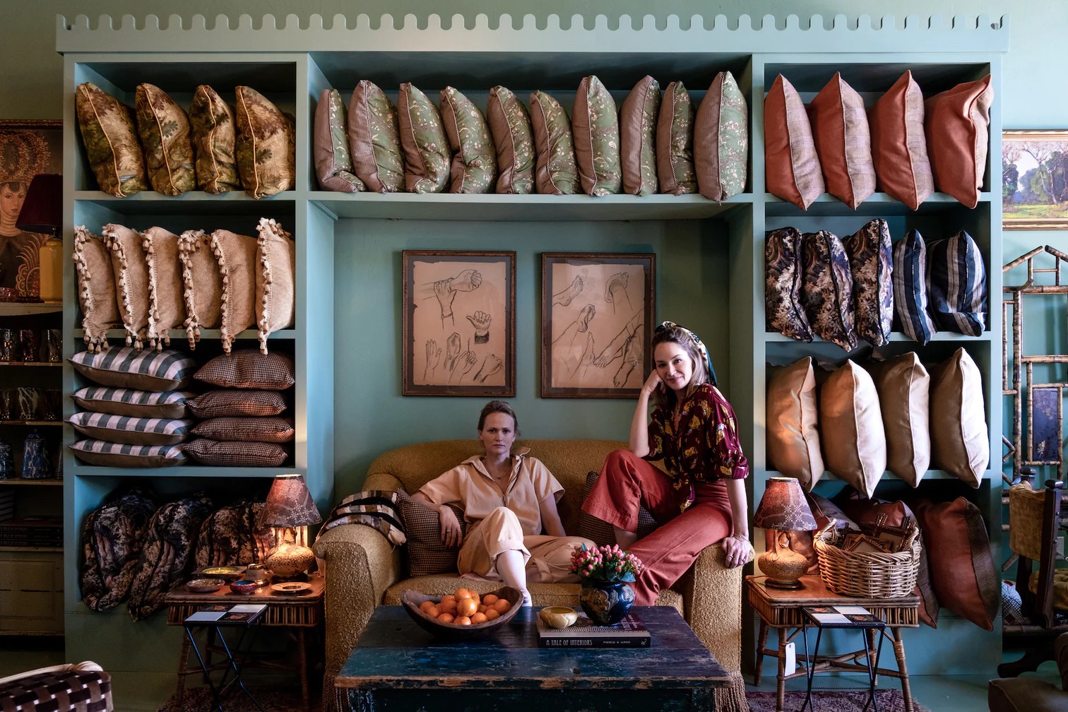 a man and a woman sitting on a couch in a room full of shoes