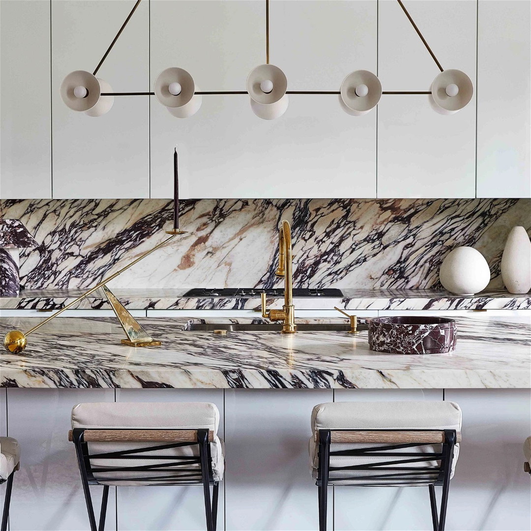 a kitchen with marble counter tops and chairs