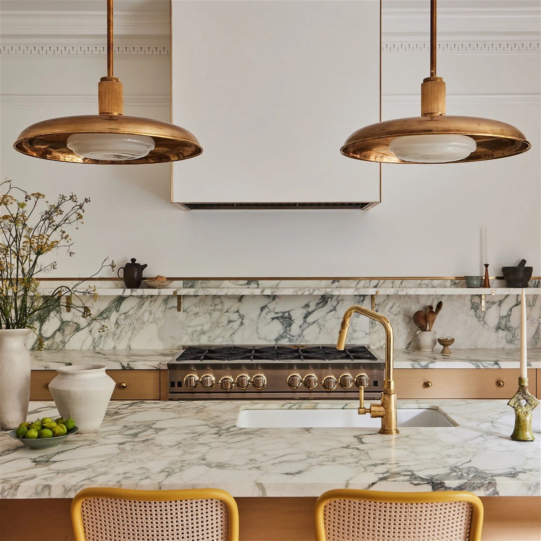 a kitchen with marble counter tops and gold fixtures