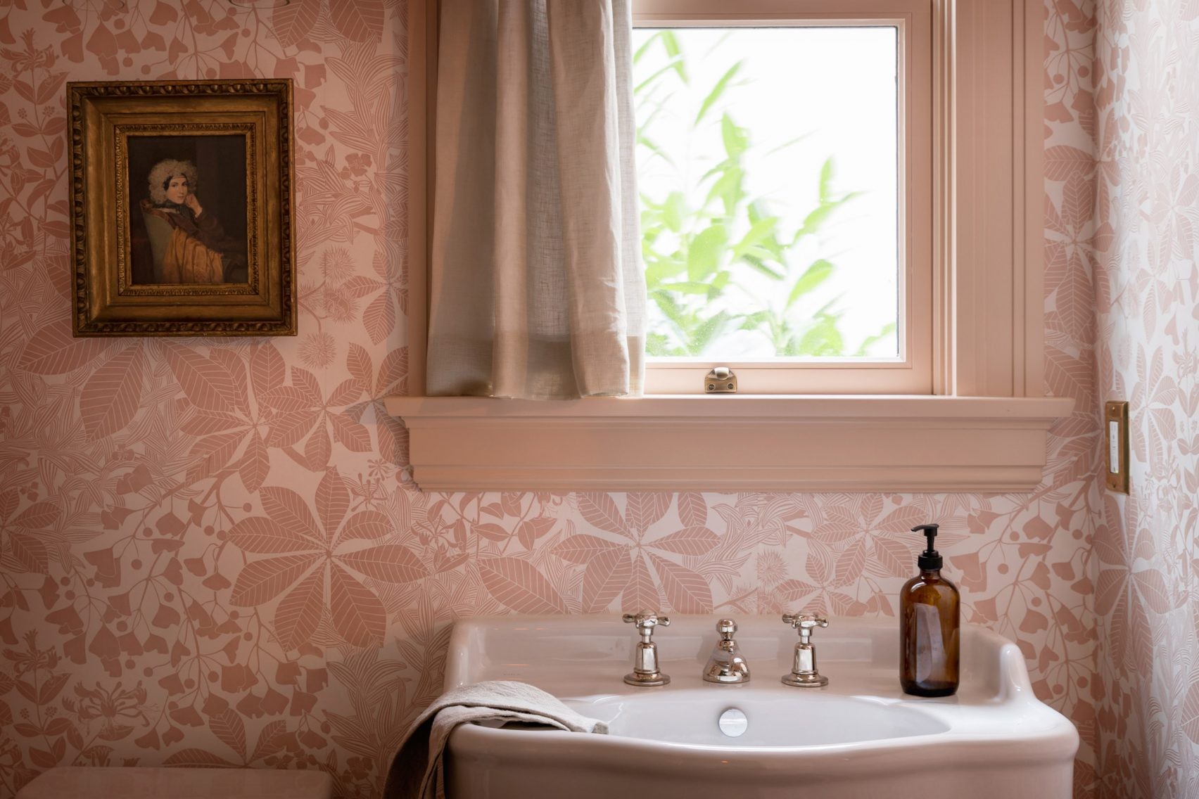 a bathroom with a sink and a painting on the wall