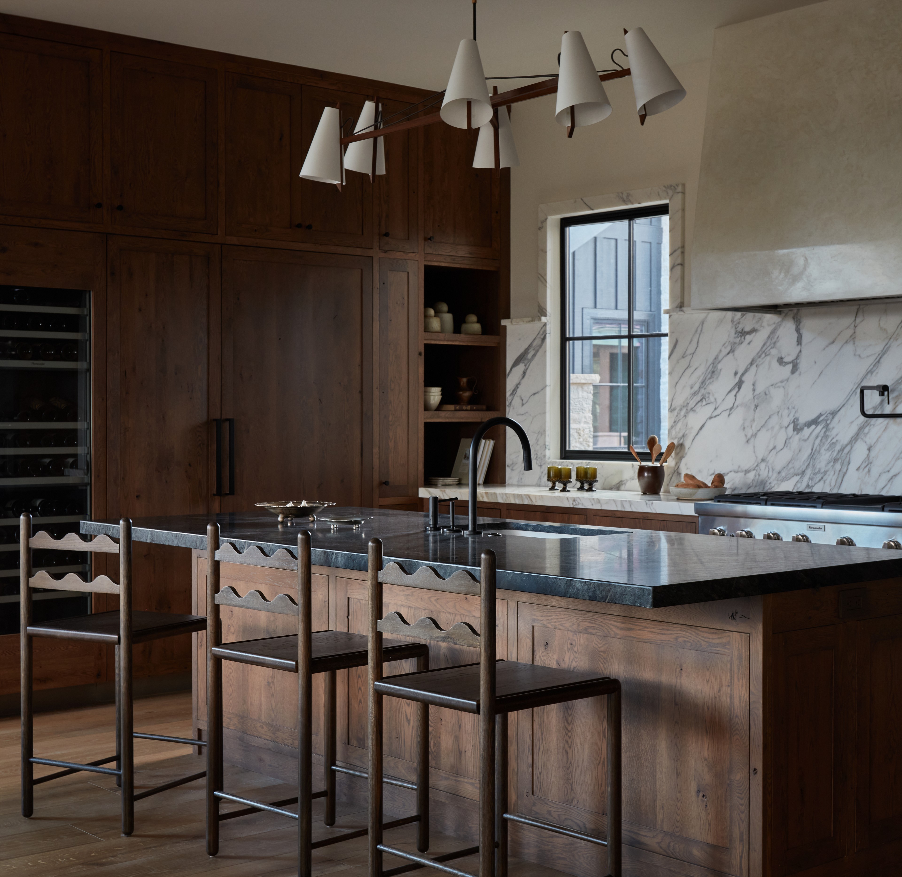 a kitchen with a marble counter top and wooden cabinets