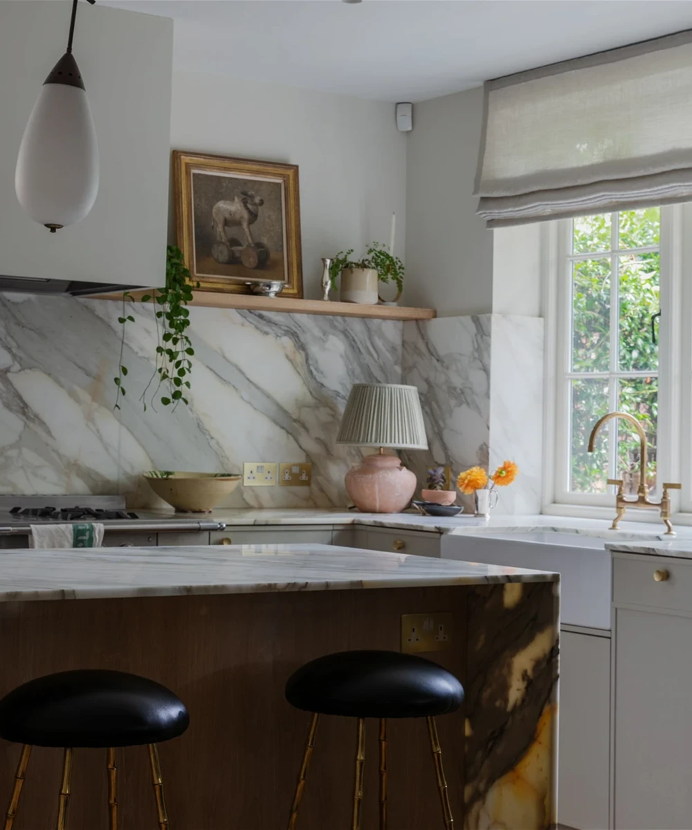 a kitchen with marble counter tops and stools