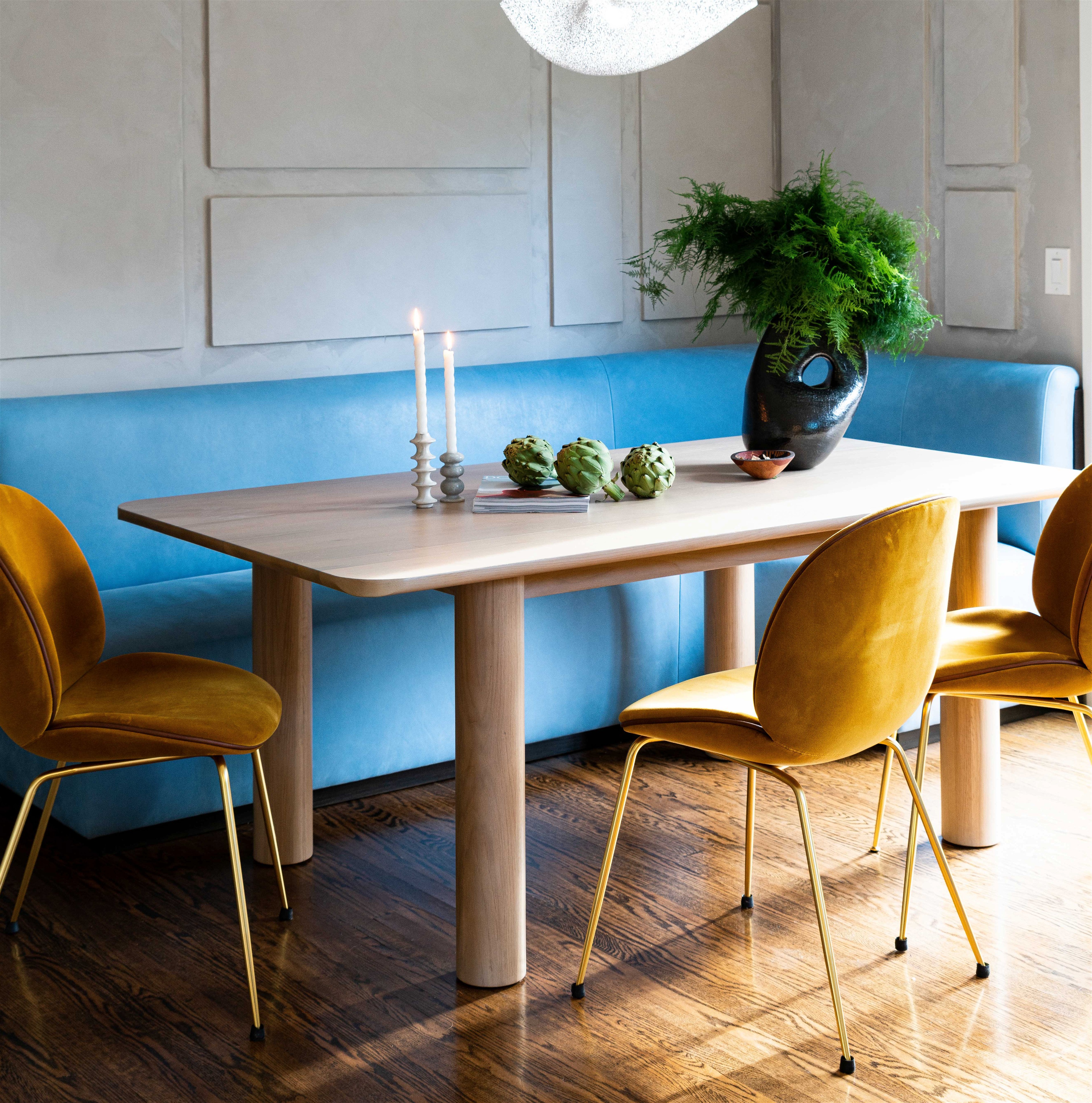 a dining room with a blue couch and a wooden table