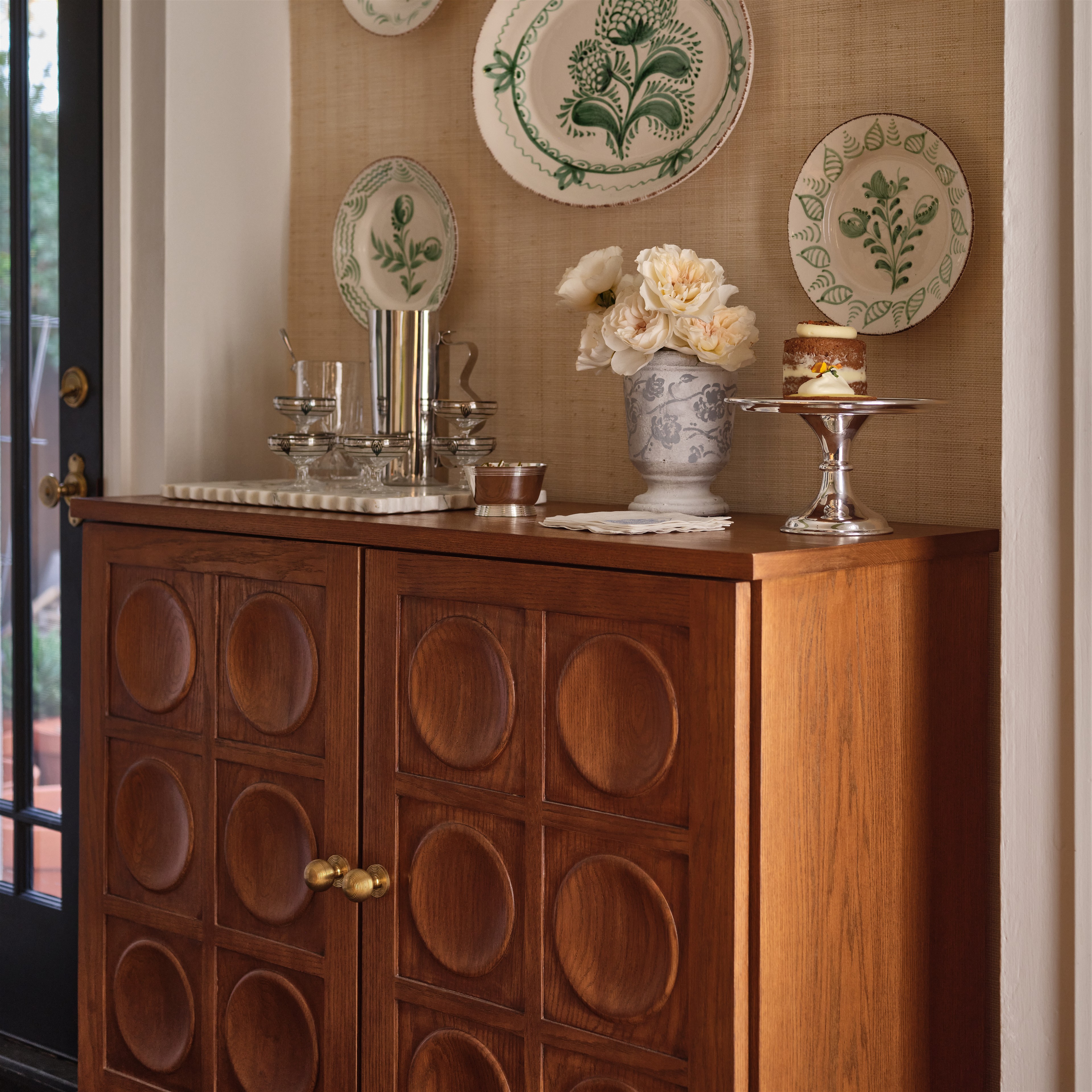 a sideboard with plates and a vase on top of it
