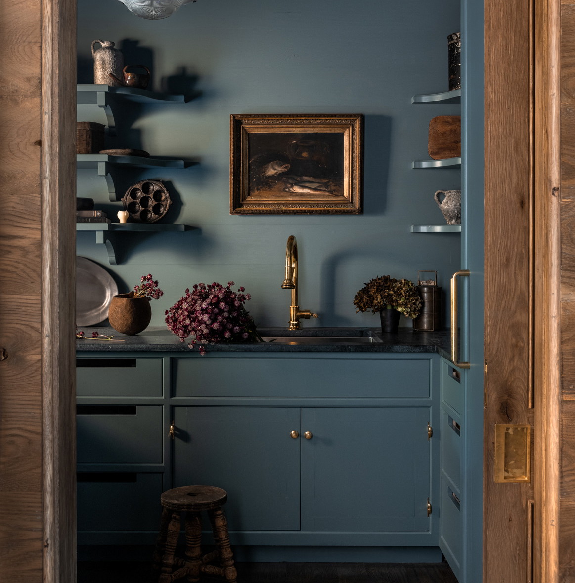 a kitchen with blue walls and a wooden door