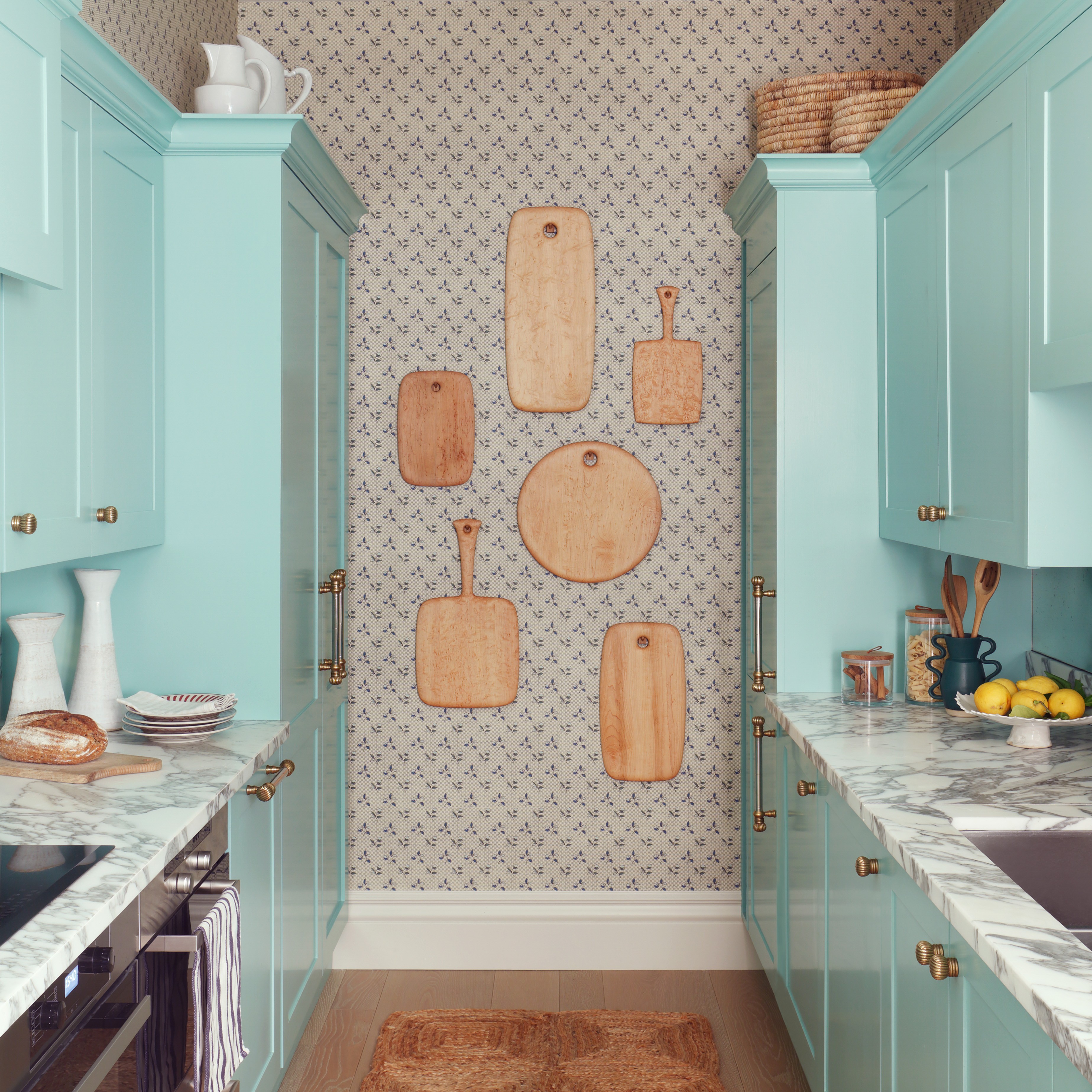 a kitchen with blue cabinets and wooden cutting boards on the wall