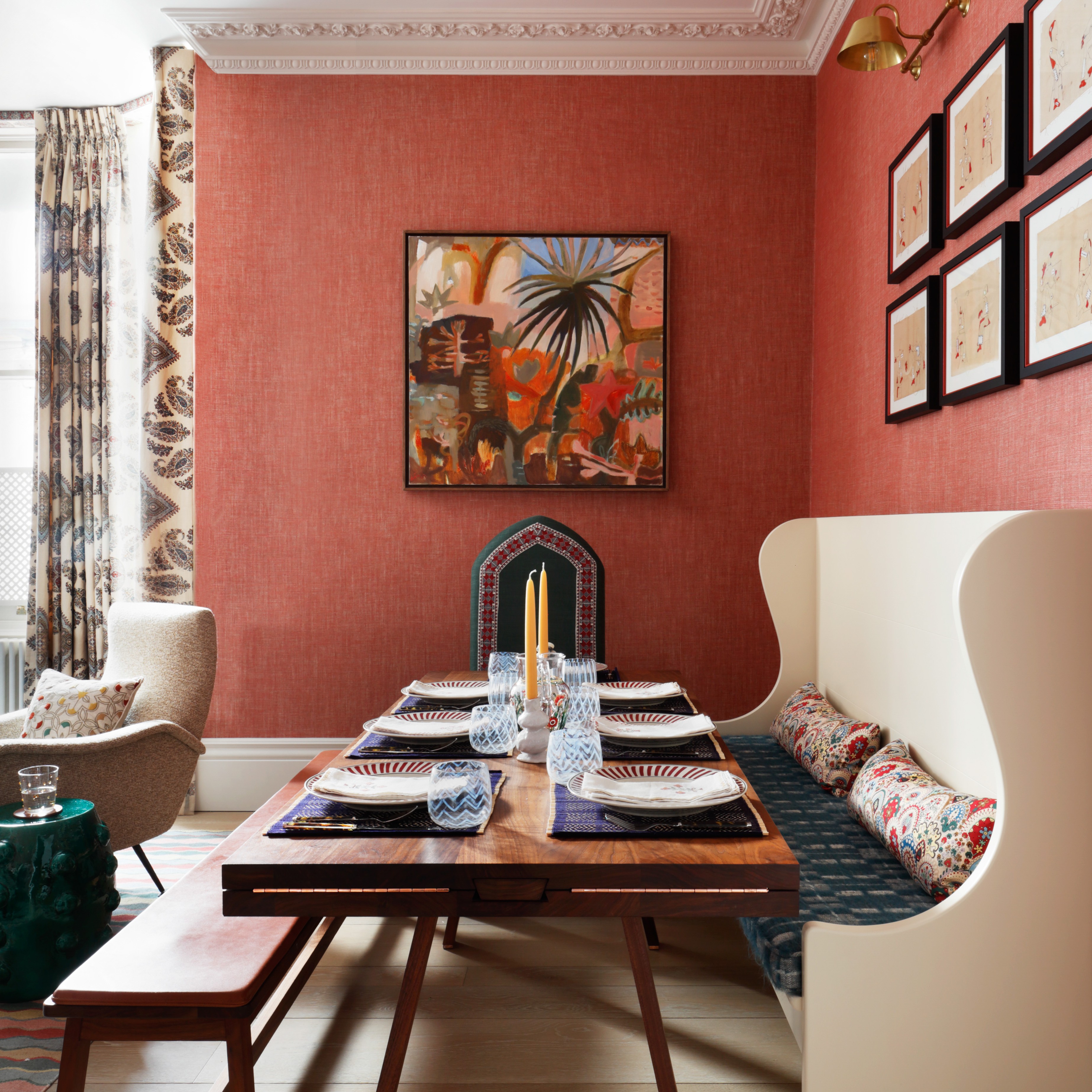 a dining room with red walls and a wooden table
