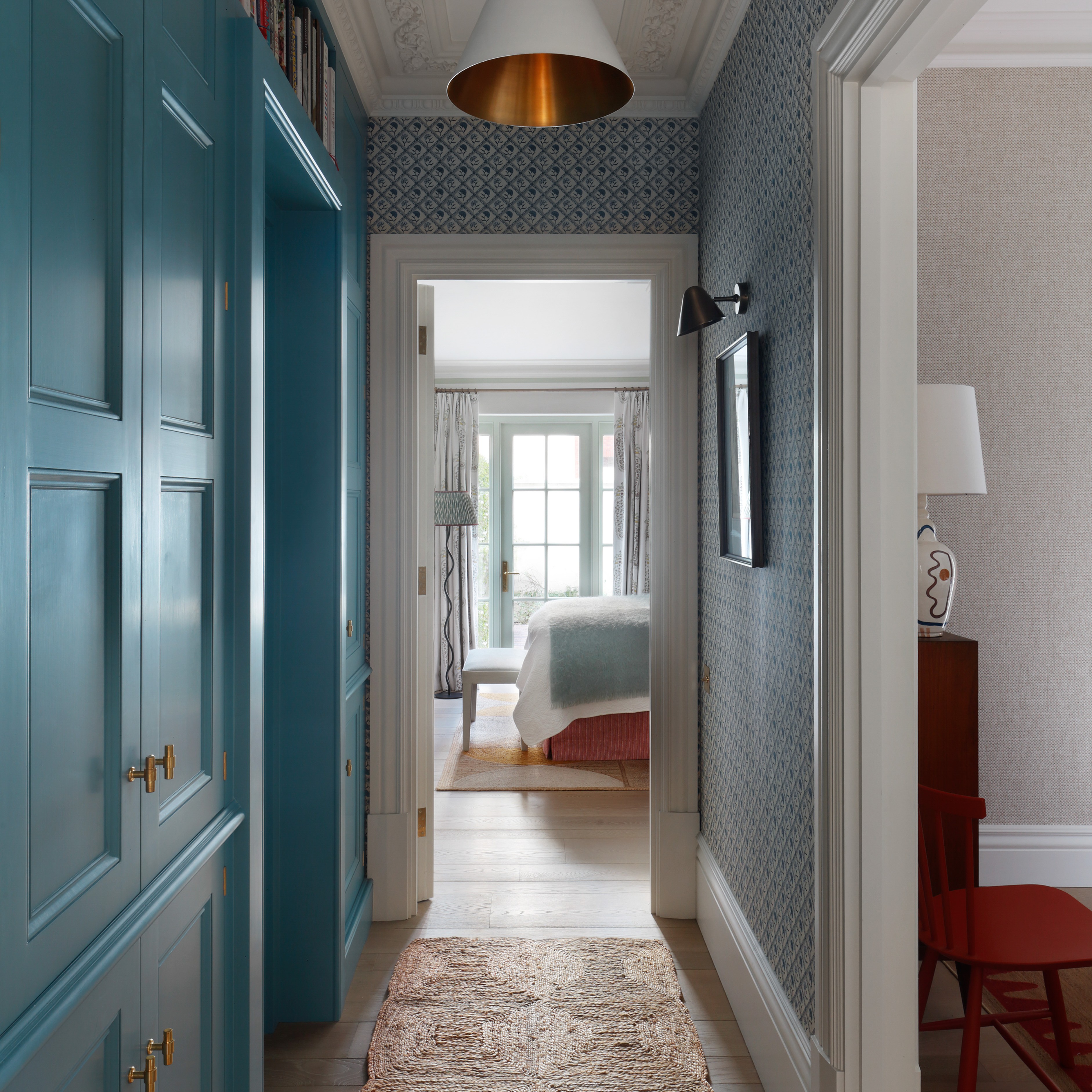 a long hallway with blue doors and a rug on the floor