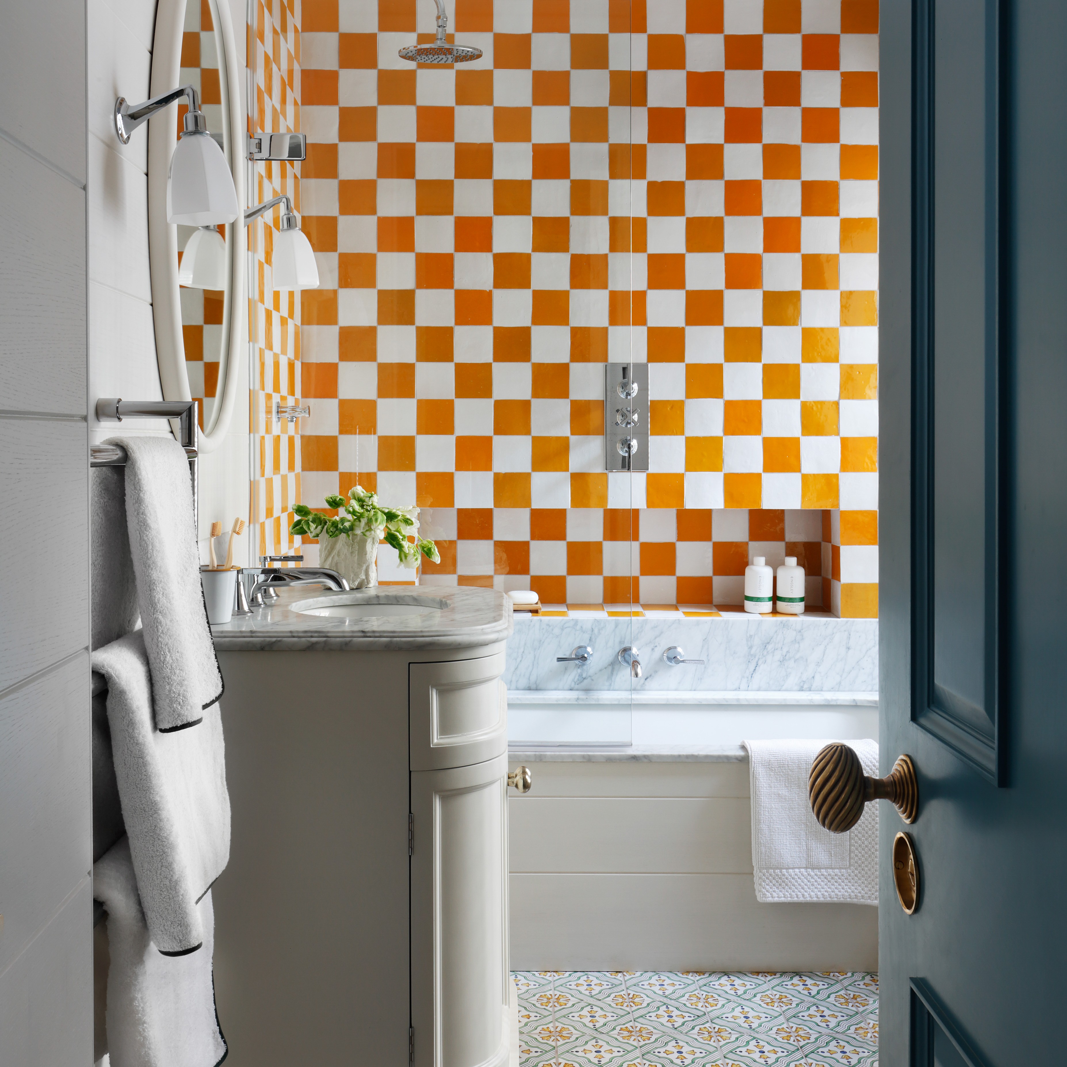 a bathroom with orange and white tiles on the wall