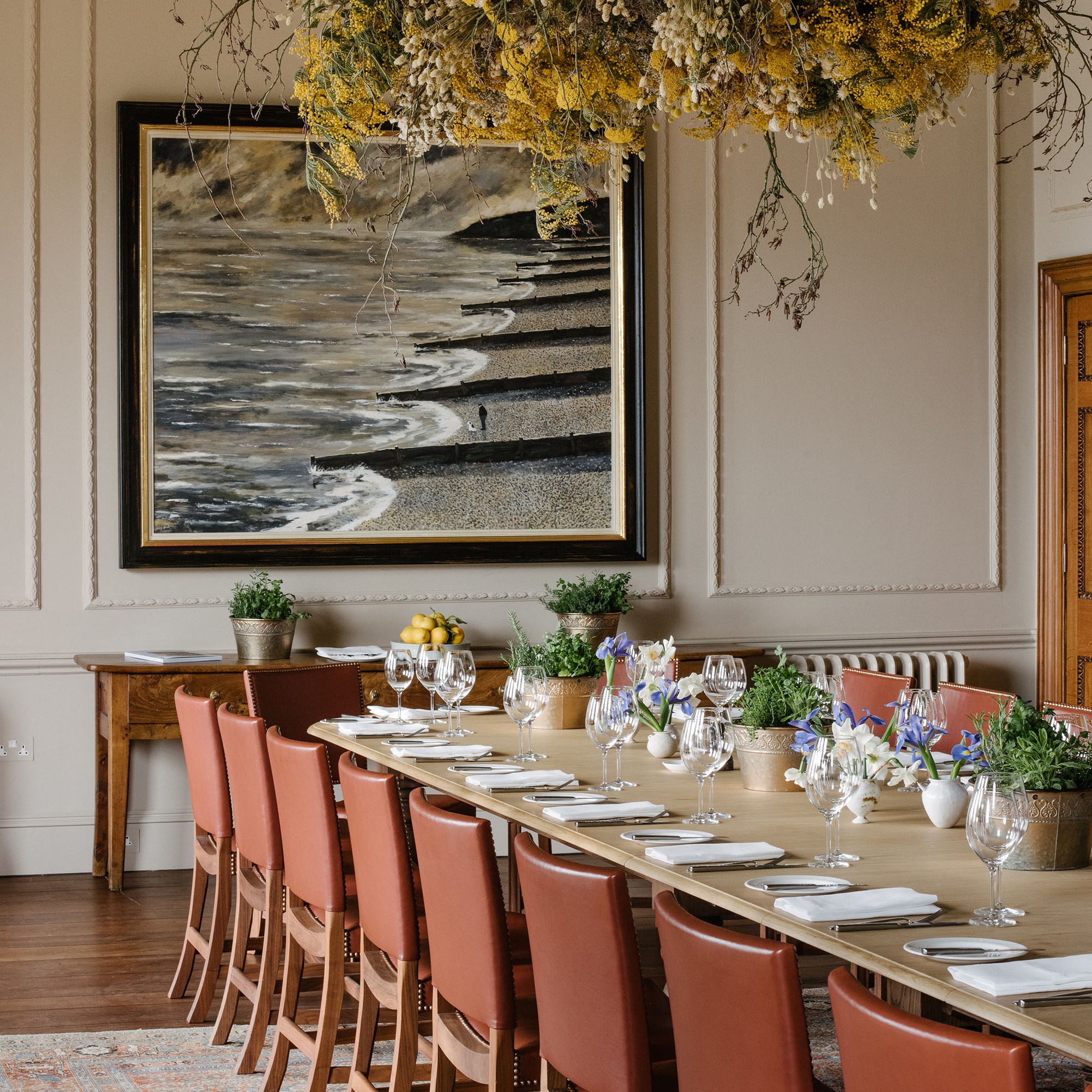 a long table with a bunch of flowers hanging over it