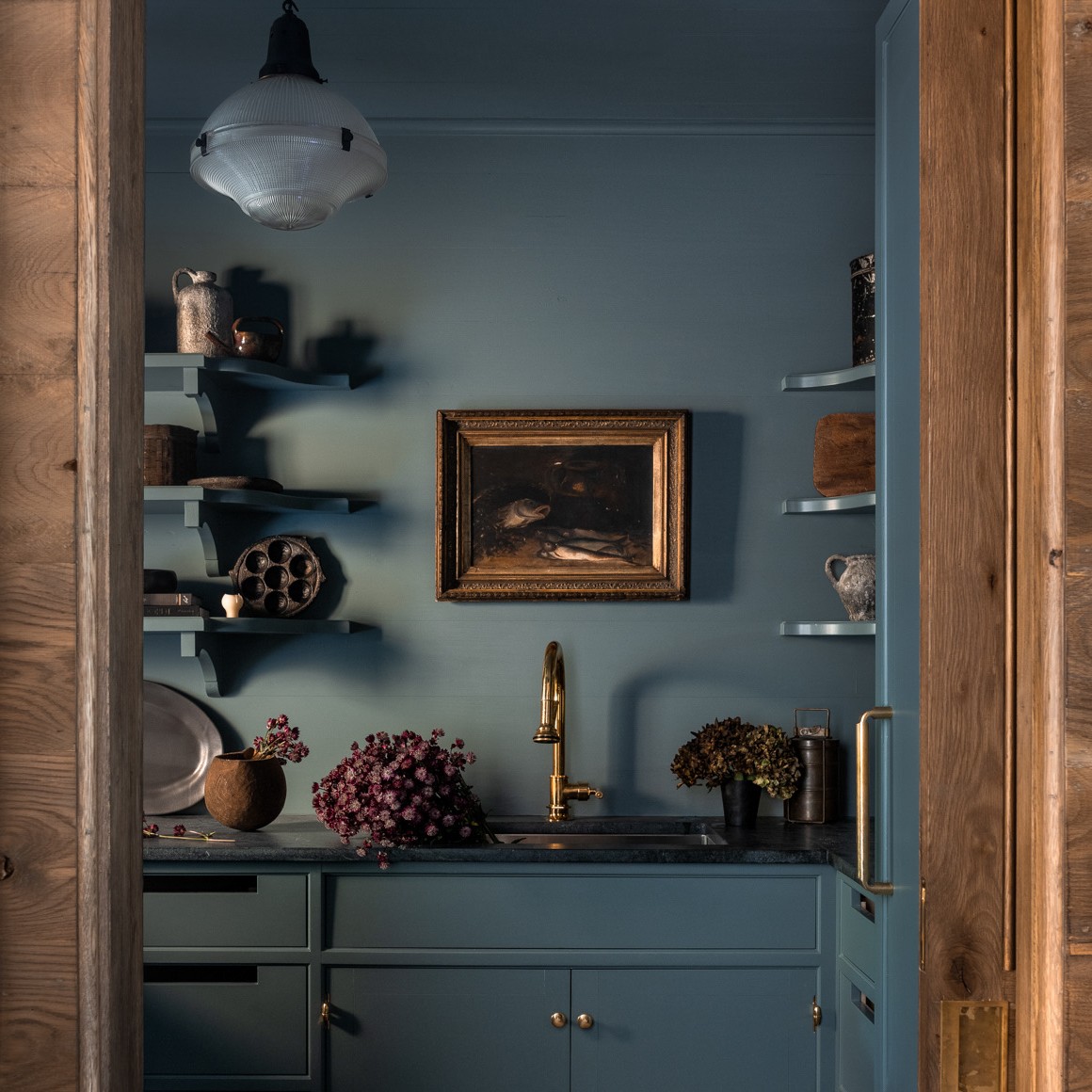 a kitchen with blue walls and a wooden door
