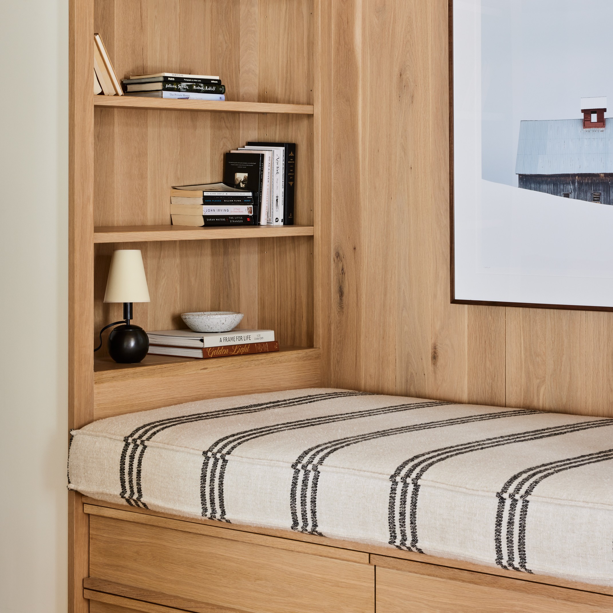 a bedroom with a bed, bookshelf and a picture on the wall