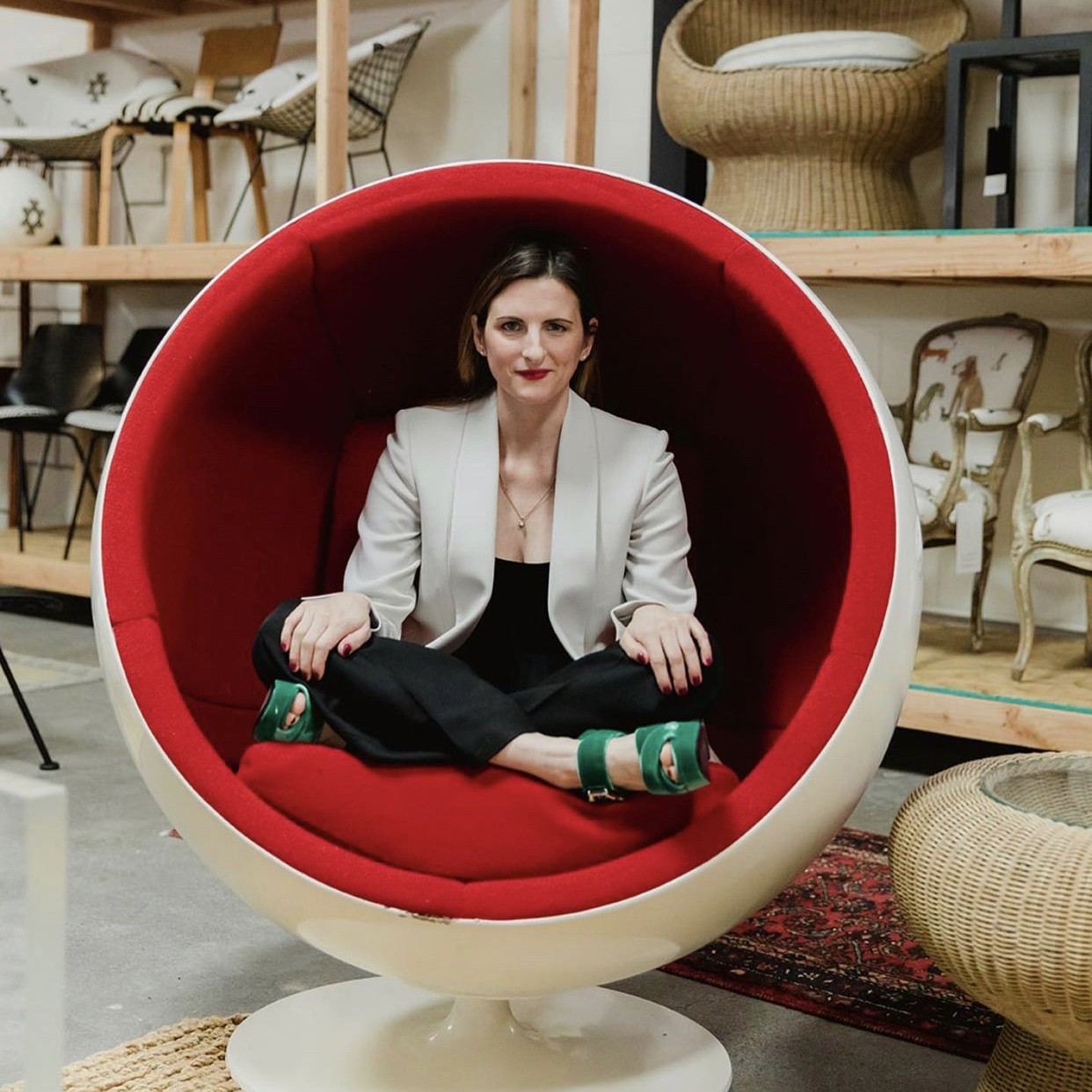 a woman is sitting in a red chair
