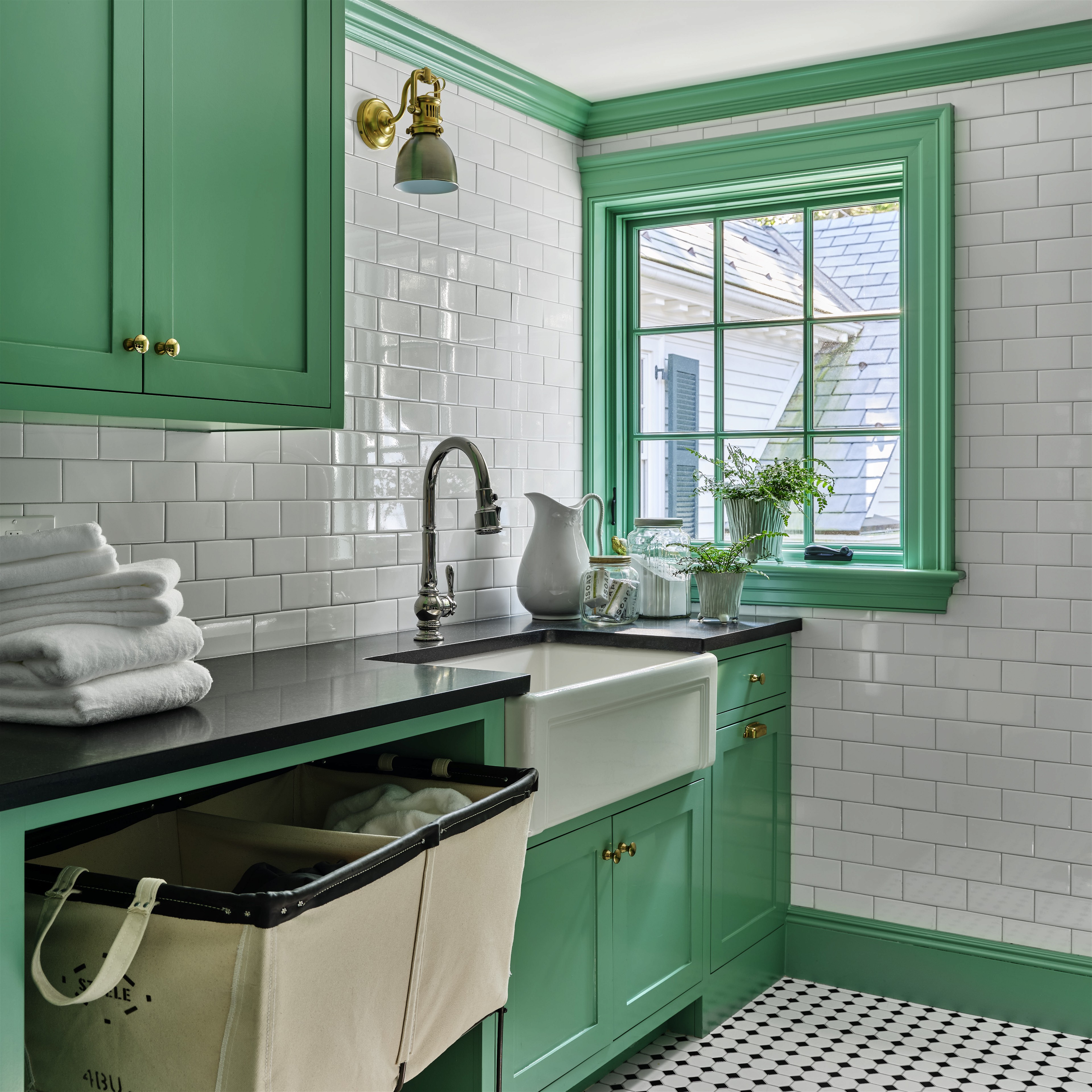 a kitchen with green cabinets and a black and white checkered floor