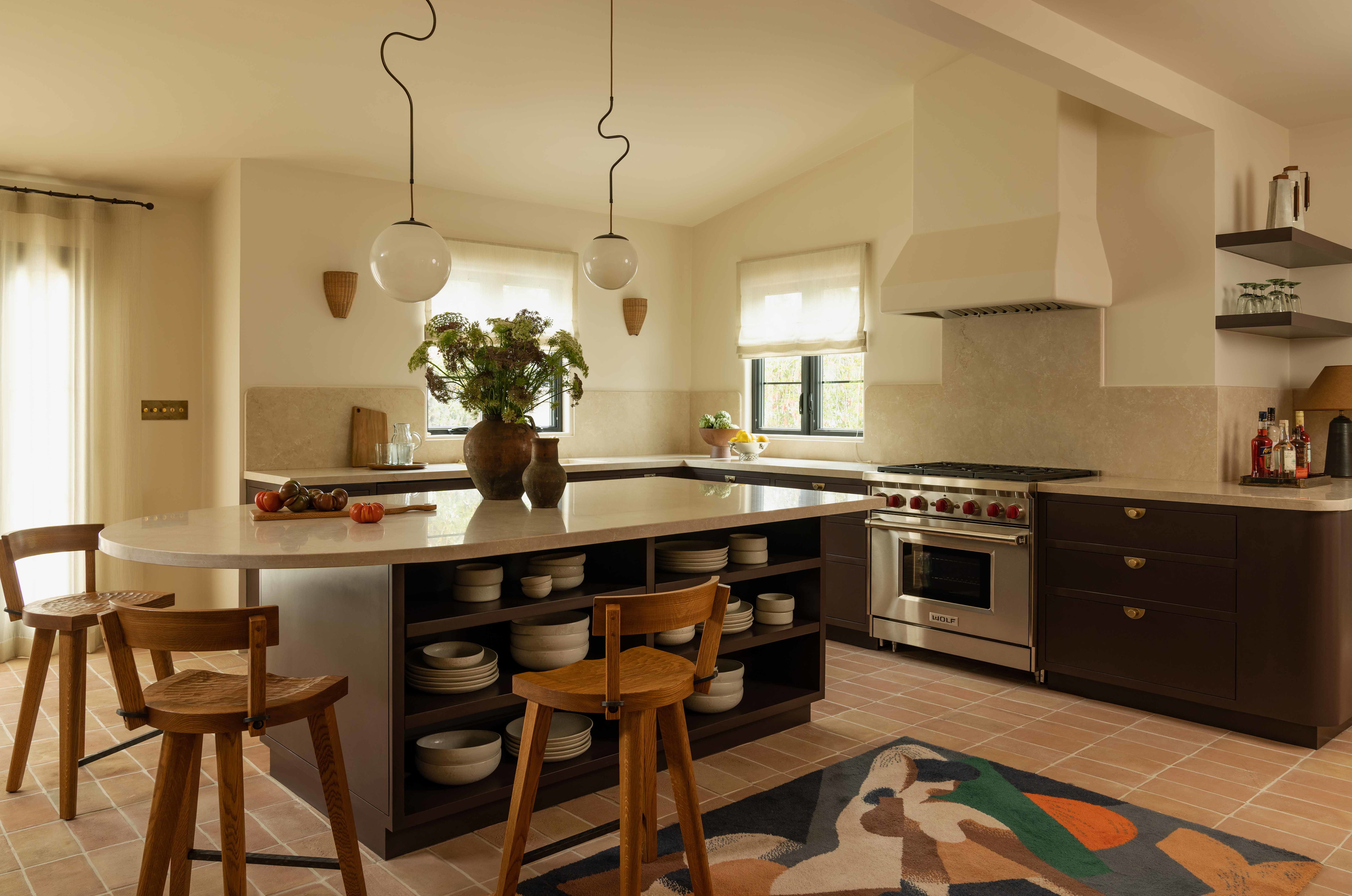 a large kitchen with a center island and wooden chairs