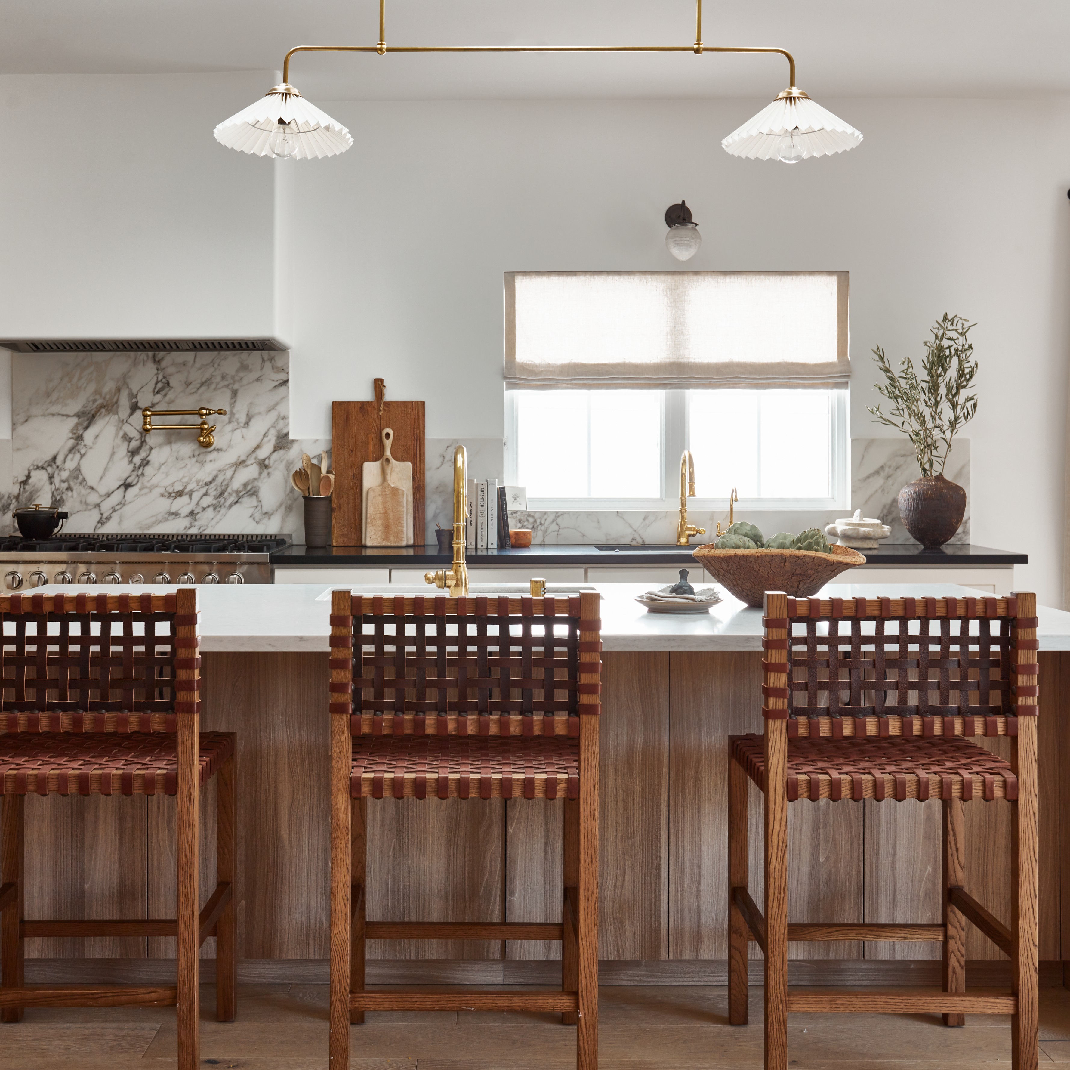 a kitchen with a marble counter top and wooden chairs