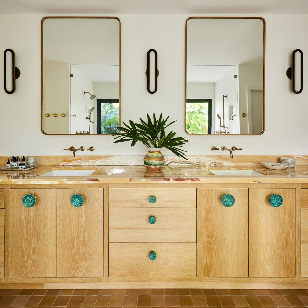 a bathroom with double sinks and mirrors on the wall