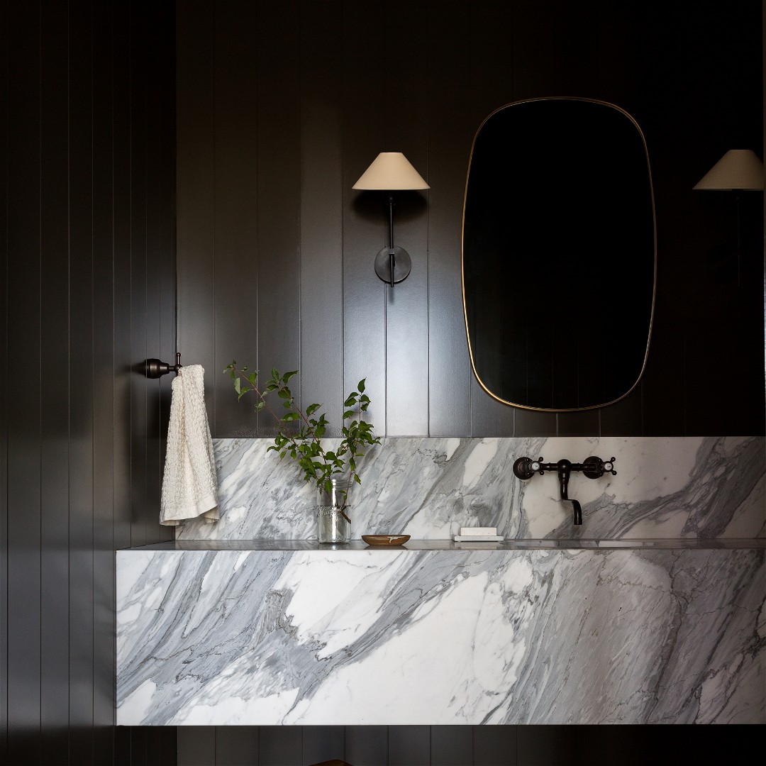 a bathroom with a marble sink and stool