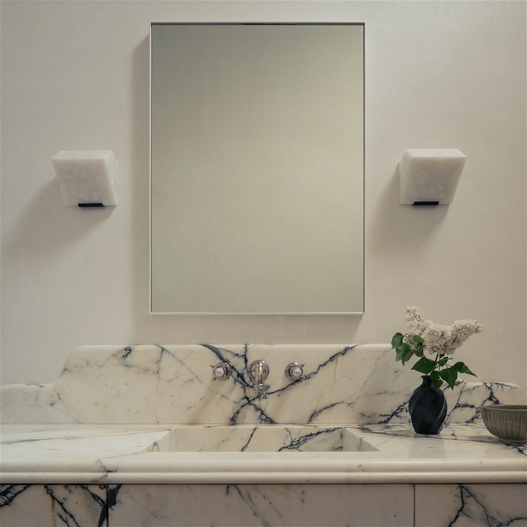 a bathroom with a marble sink and a mirror