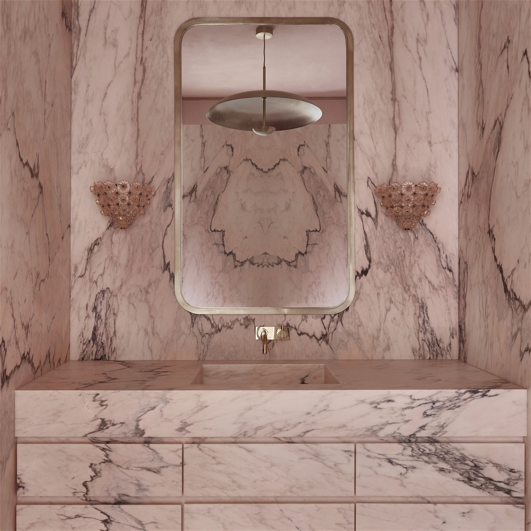 a bathroom with a marble vanity and a large mirror