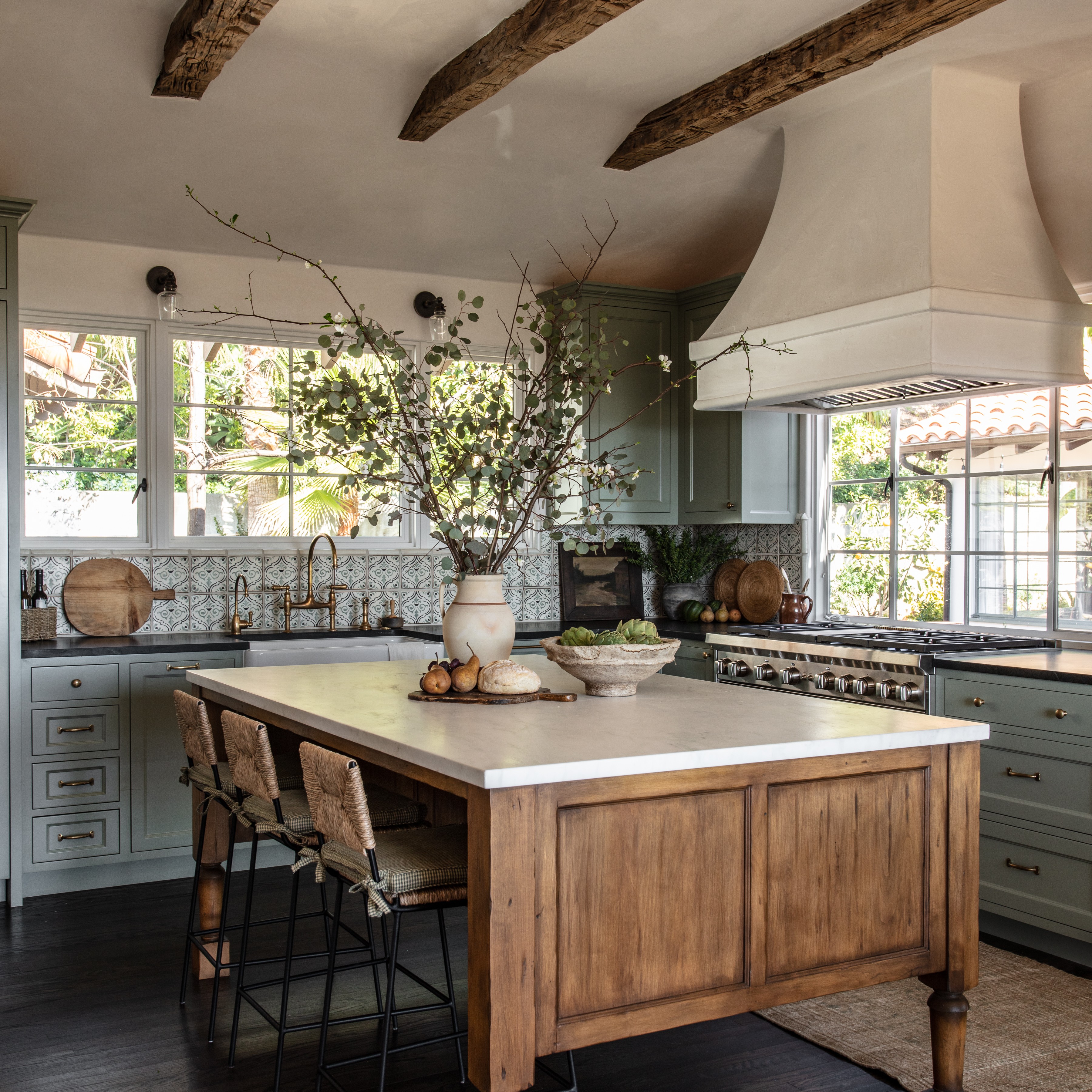 a large kitchen with a center island and wooden beams