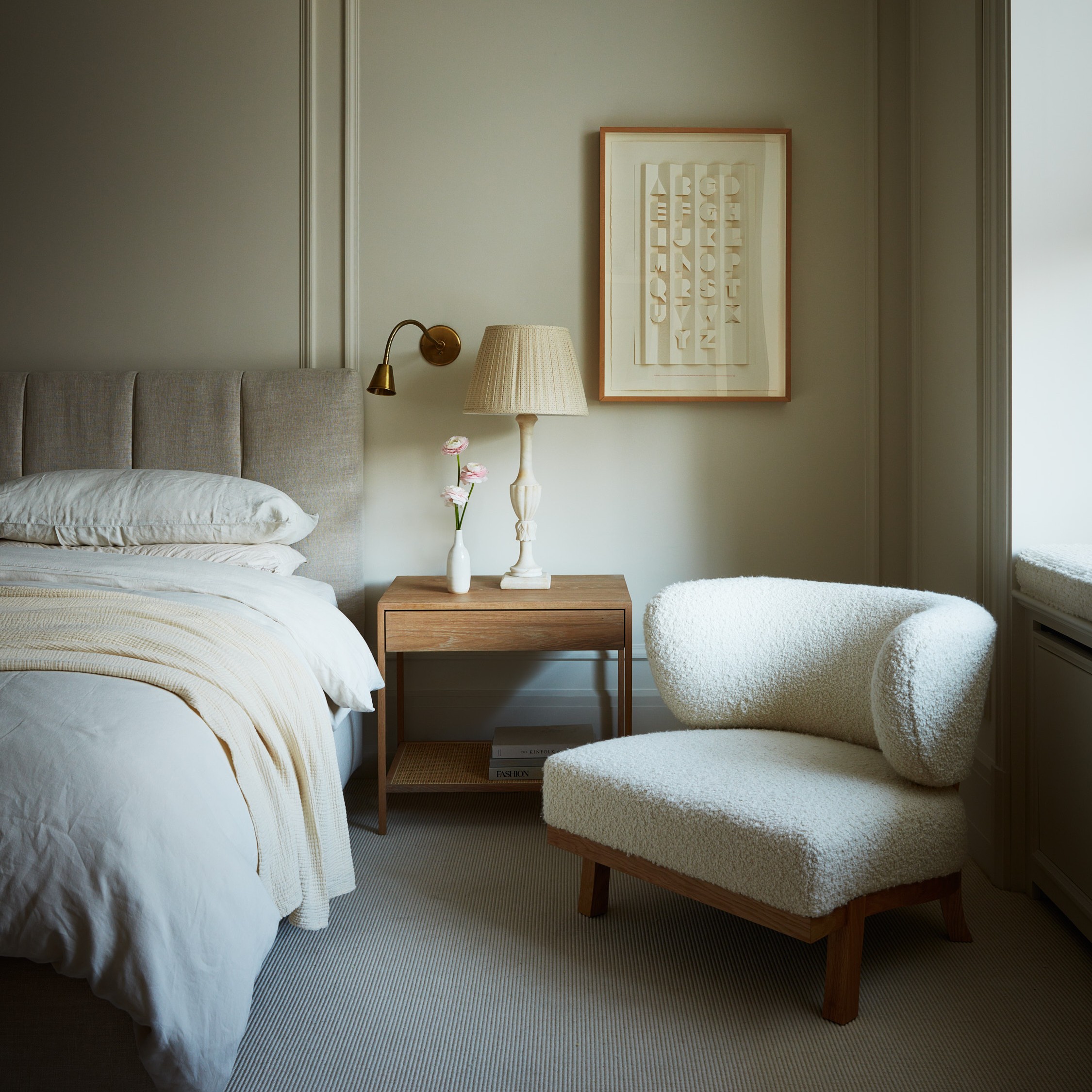 a bed room with a neatly made bed and a chair