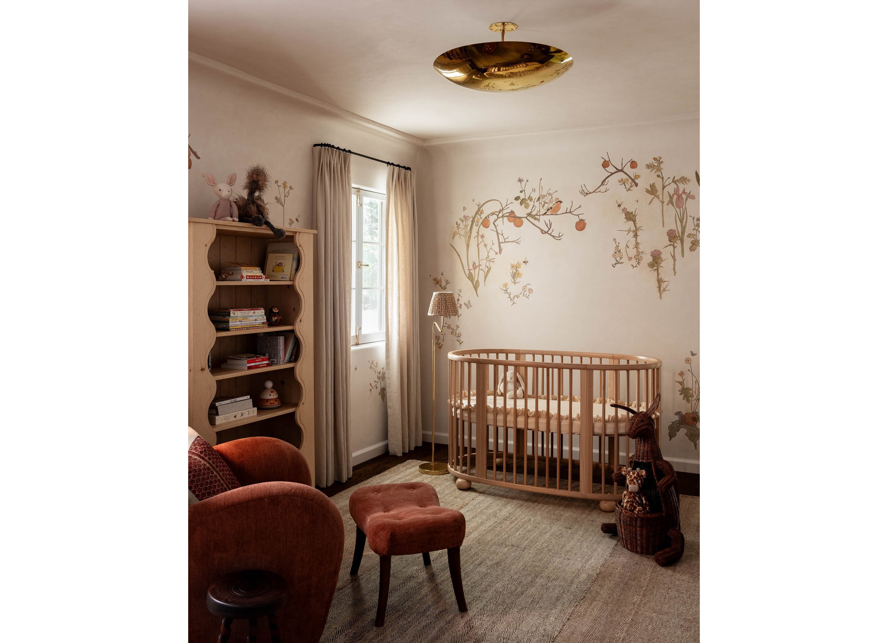 a baby's room with a crib, chair, and bookcase