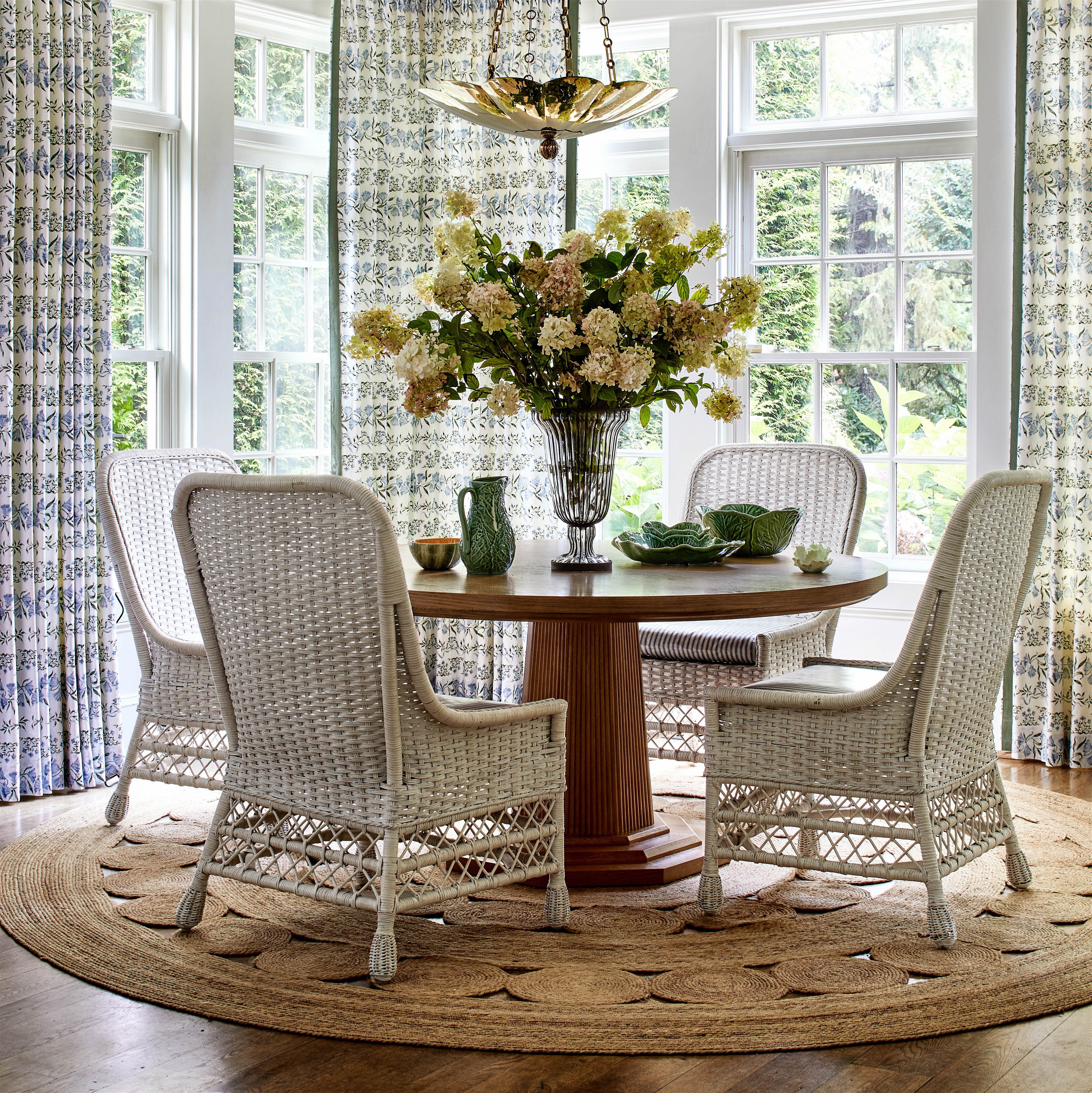 a dining room table with chairs and a vase of flowers