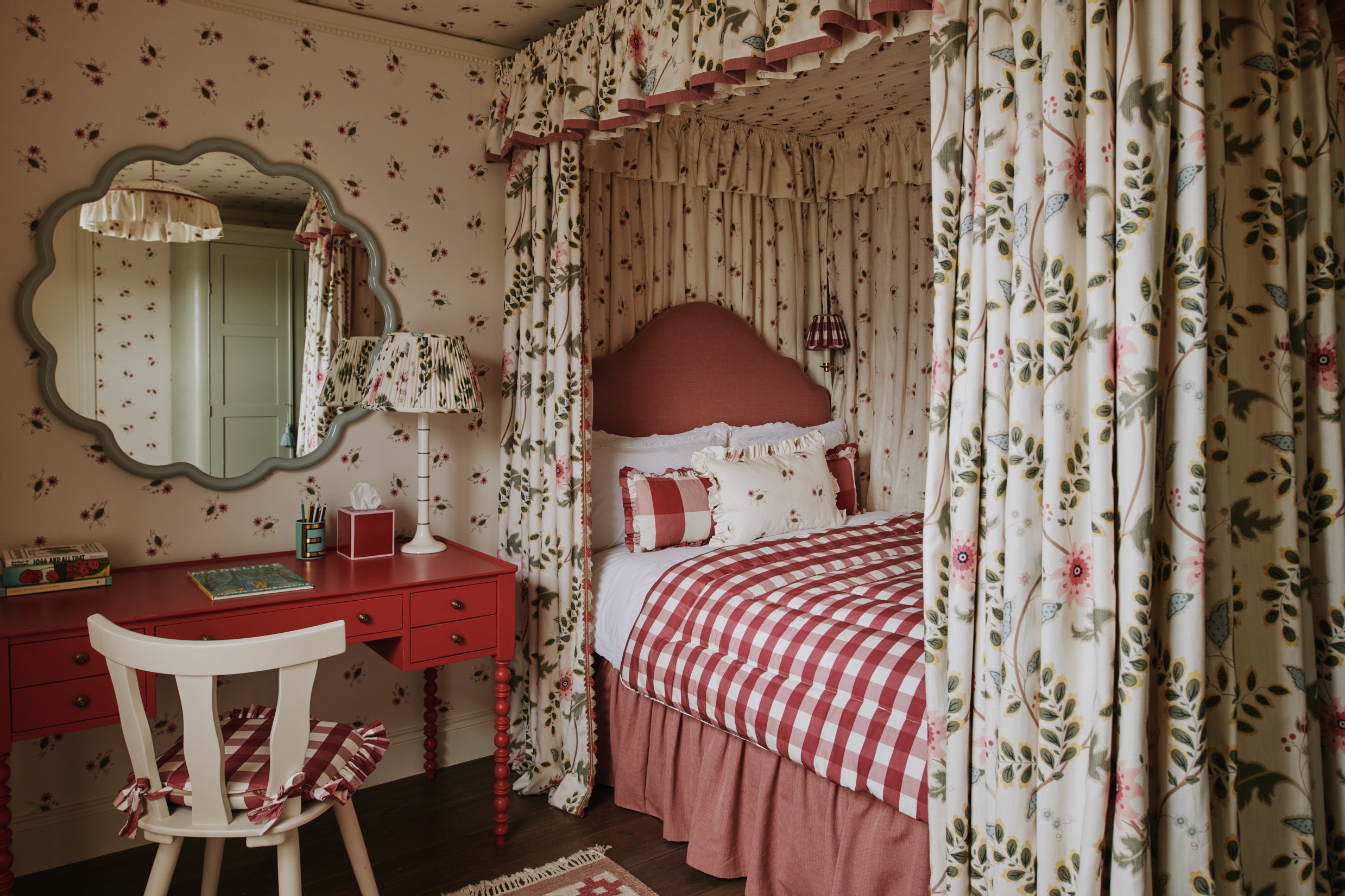 a bedroom with a canopy bed and a red desk