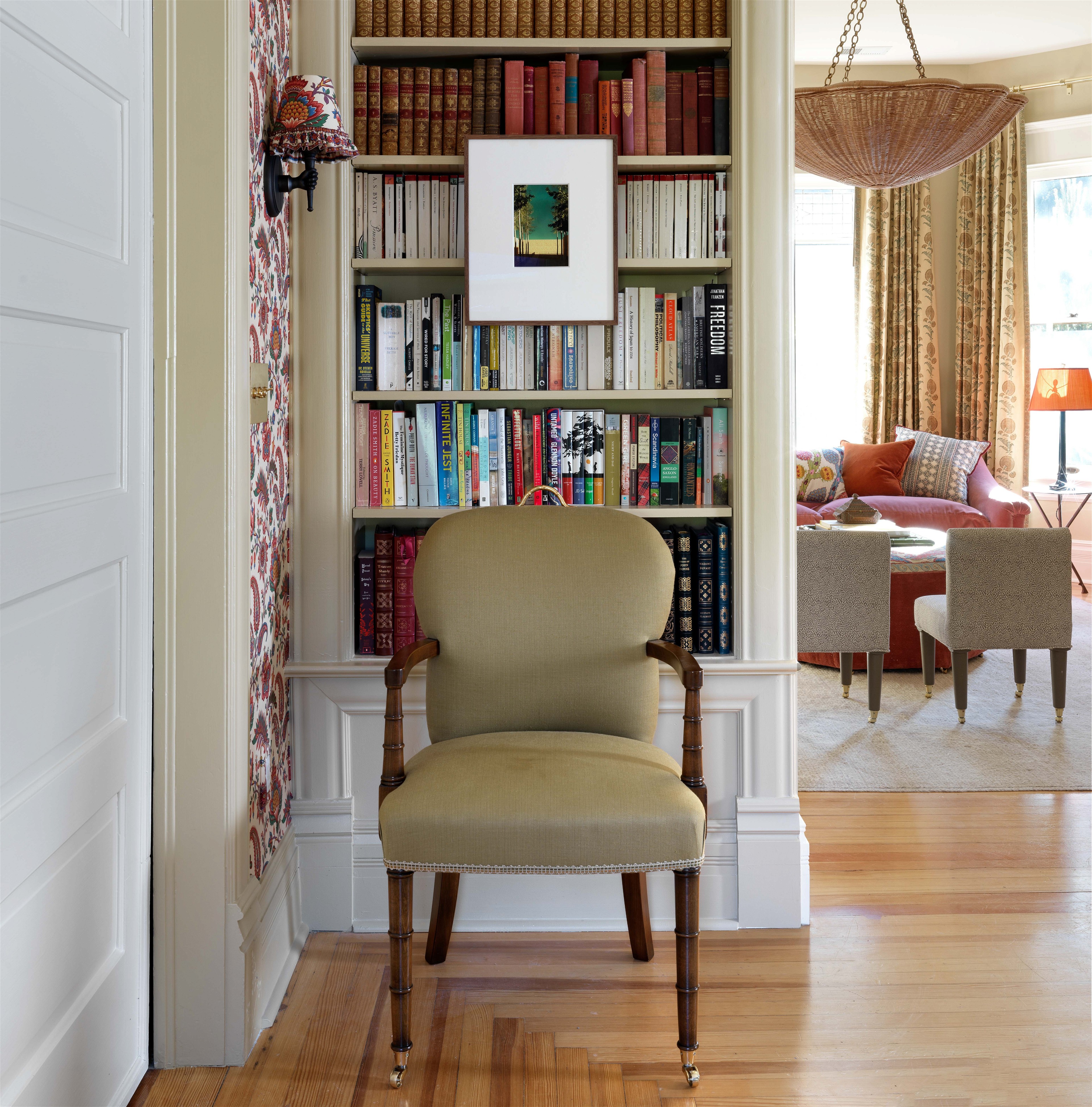 a chair in a room with a bookcase full of books