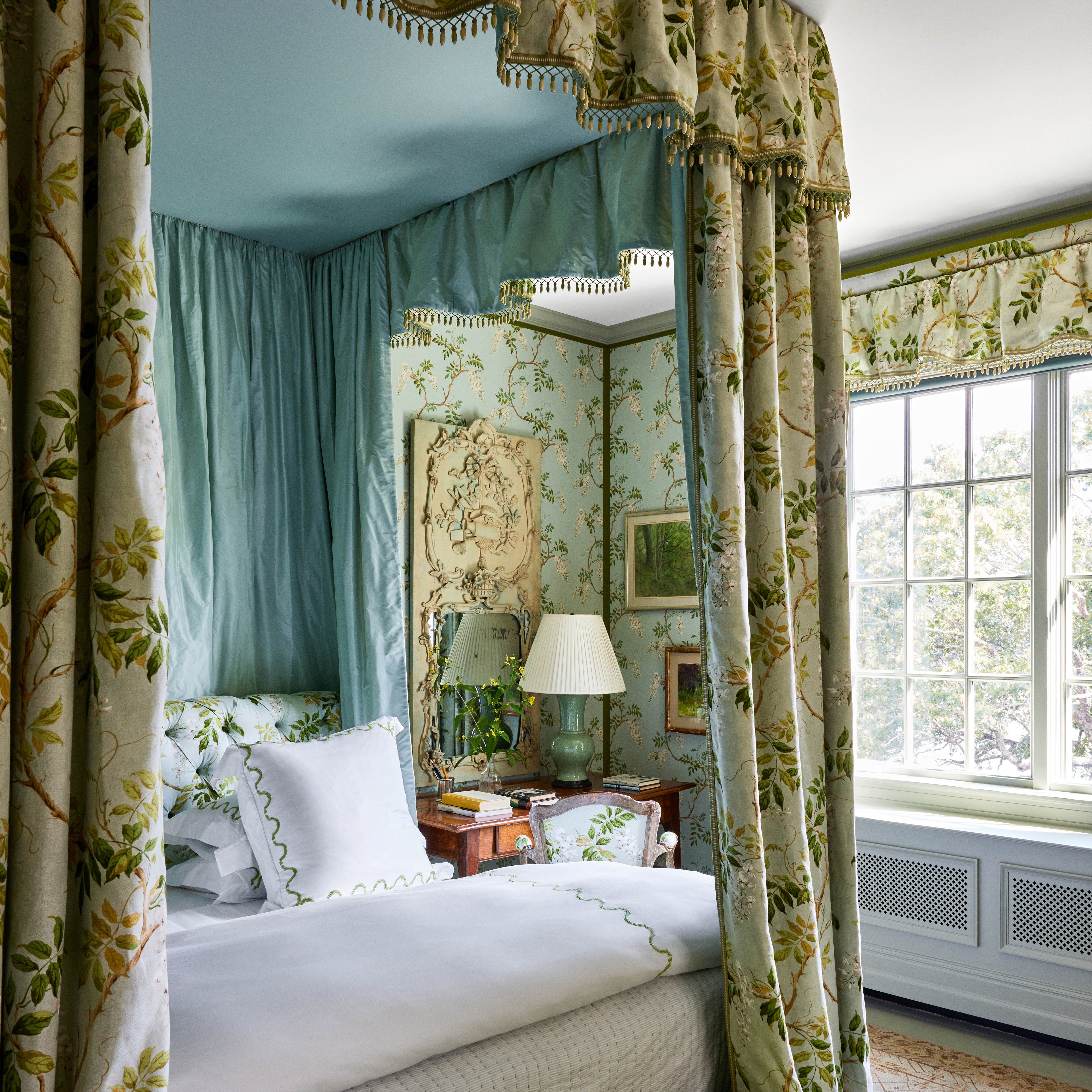 a bedroom with a canopy bed and a green bench
